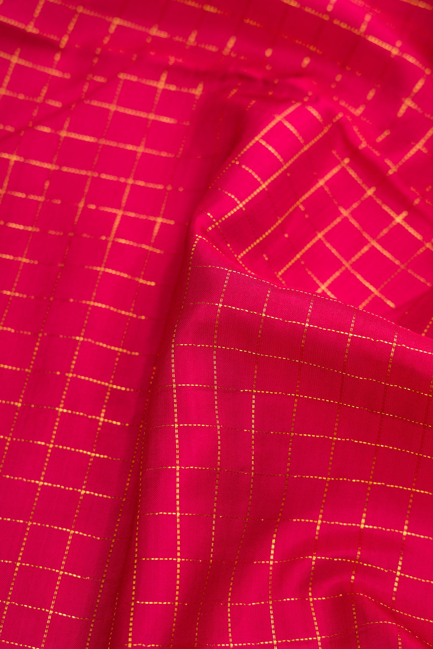 Close up of Red Dual Tone Kanchipuram Silk Saree with Checked design on the body and Zari Border.  displaying folds