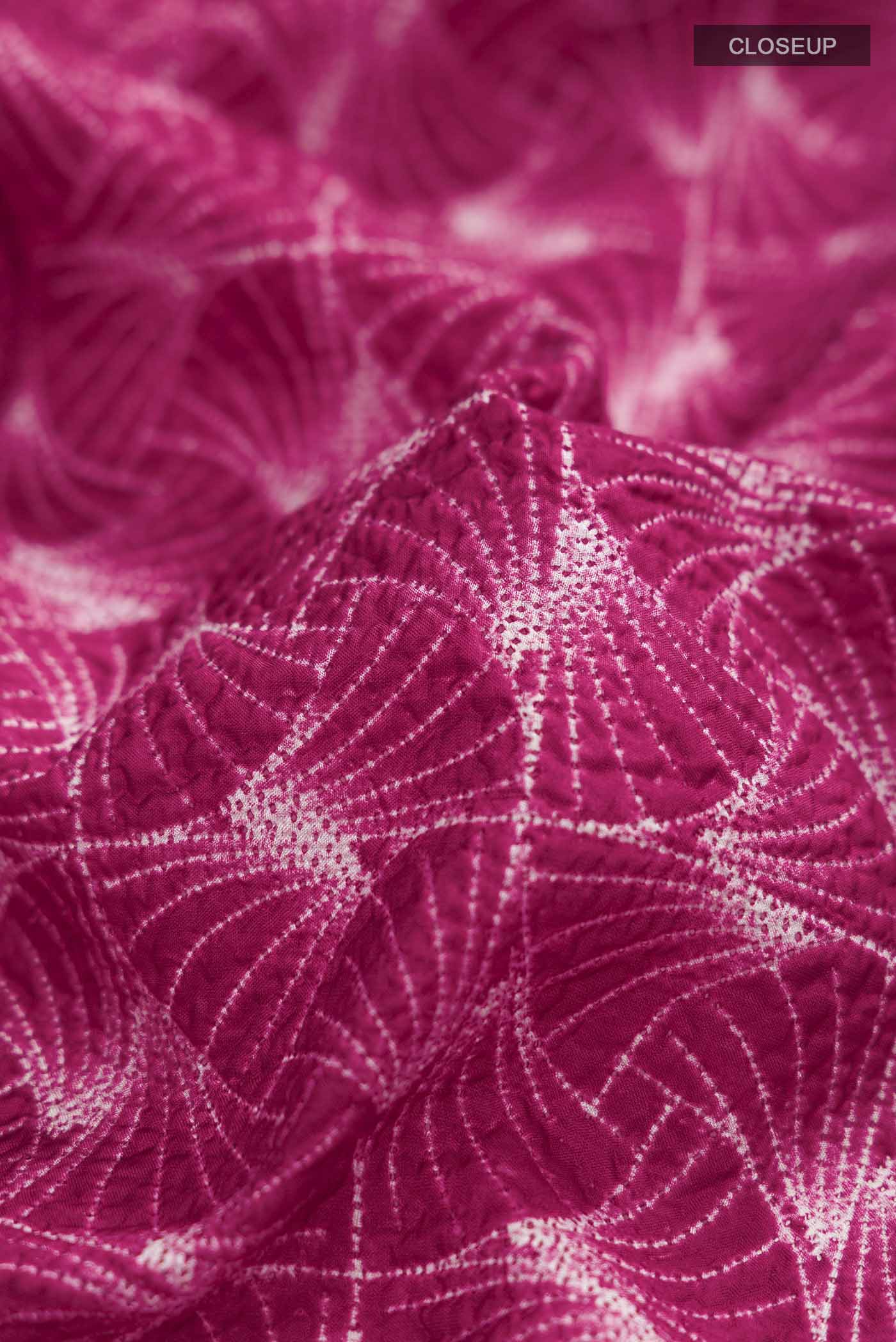 Close up of Maroon Printed Silk Saree Printed design on the body and Without Border displaying folds