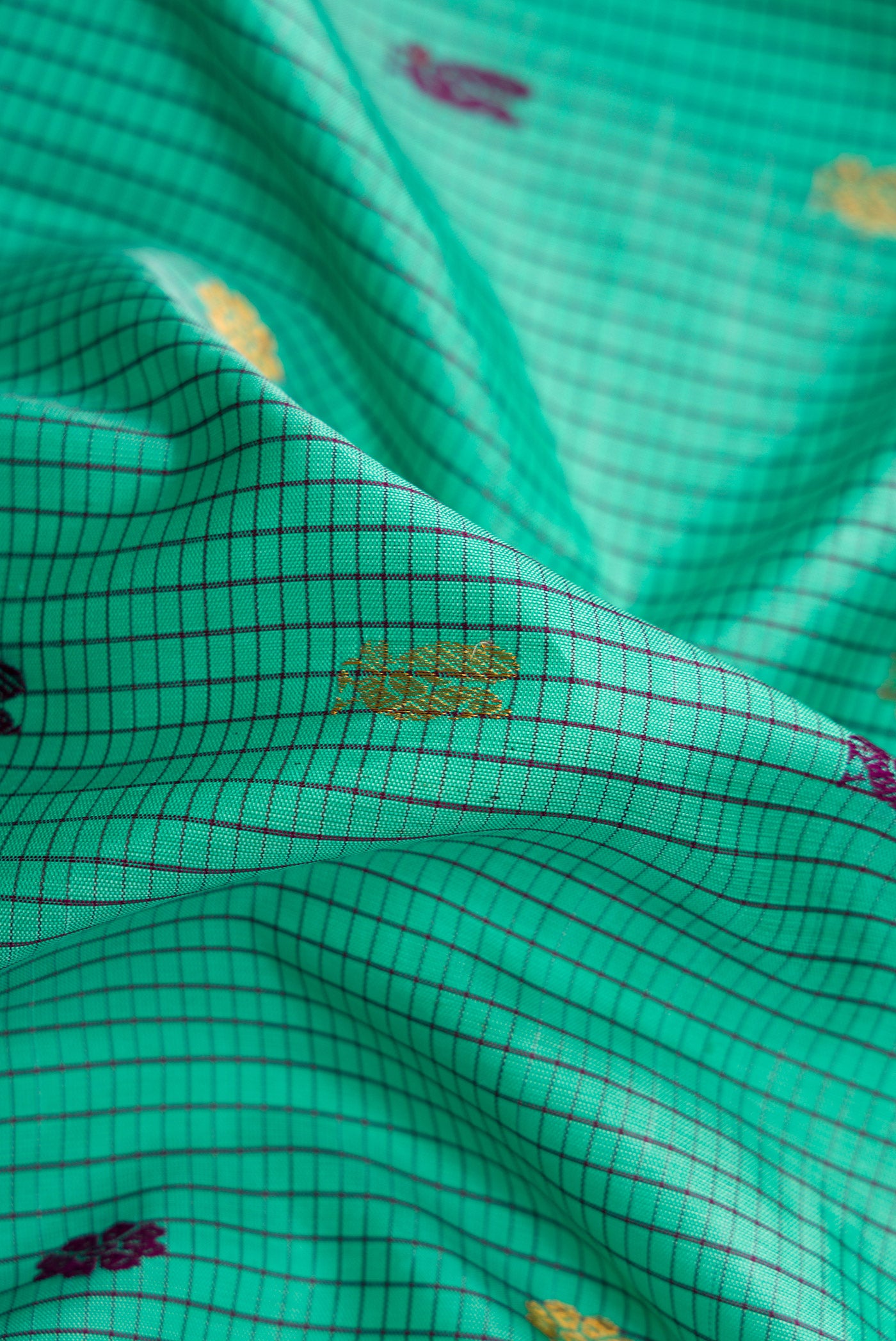 Close up of Sea Green Dual Tone Gadwal Silk Saree with Checked design on the body and Zari Border.  displaying folds