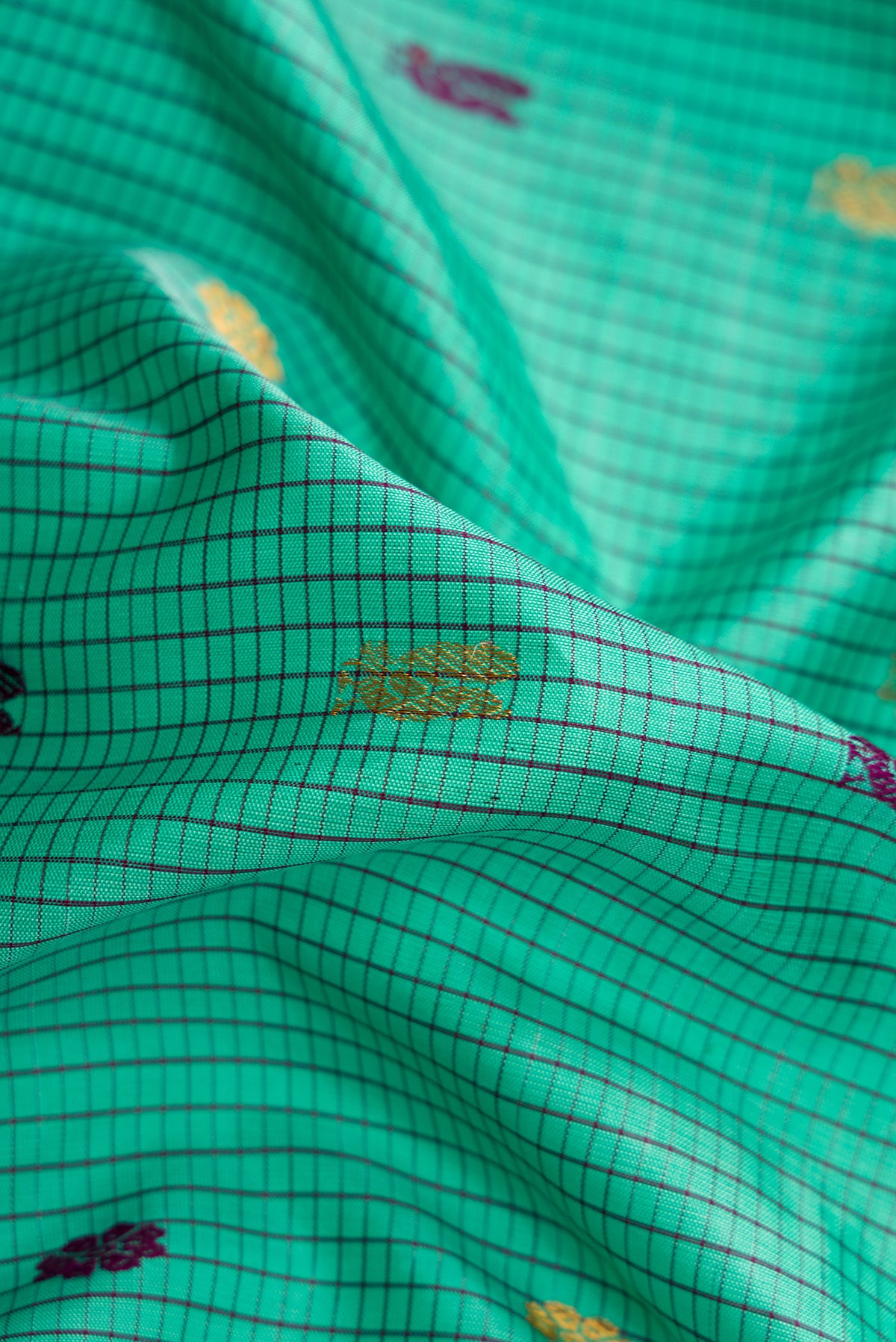 Close up of Sea Green Dual Tone Gadwal Silk Saree with Checked design on the body and Zari Border.  displaying folds