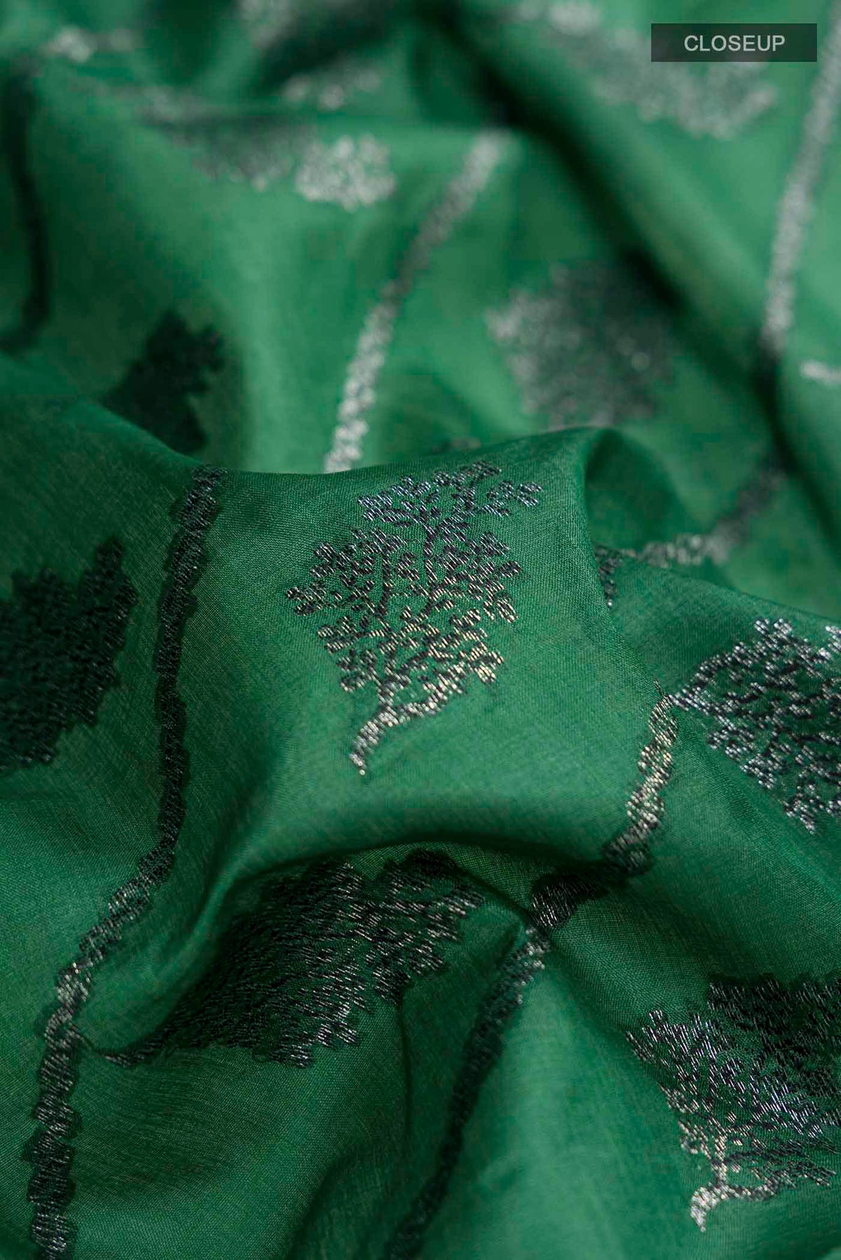 Close up of Green Banarasi Tussar Silk Saree with Zari And Thread Butta on the body and Zari And Thread Border displaying folds