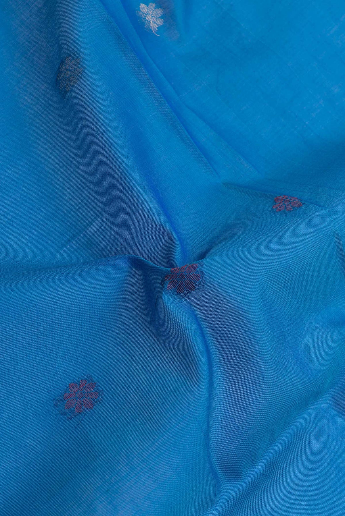 Close up of Sky Blue Dual Tone Silk Cotton Saree with Zari Butta on the body and Zari Border.  displaying folds