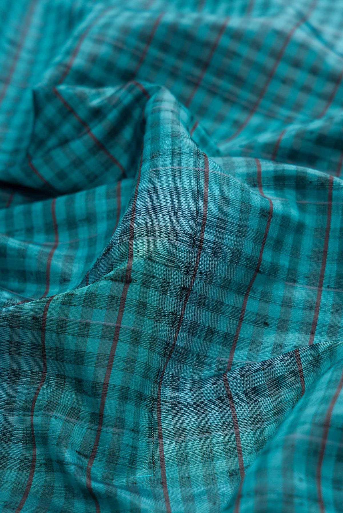Close up of Maya Blue Dual Tone Soft Silk Saree with Checked design on the body and Zari Border displaying folds