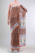Rust Silk Cotton Saree with Printed design on the body and Zari Border displayed on a mannequin