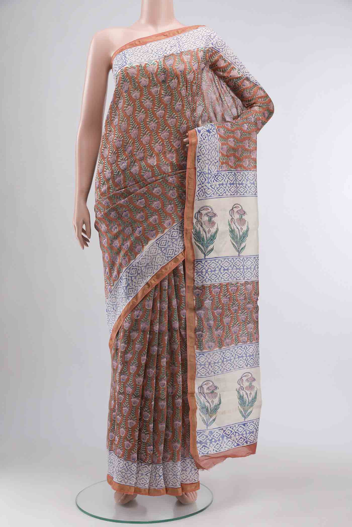 Rust Silk Cotton Saree with Printed design on the body and Zari Border displayed on a mannequin