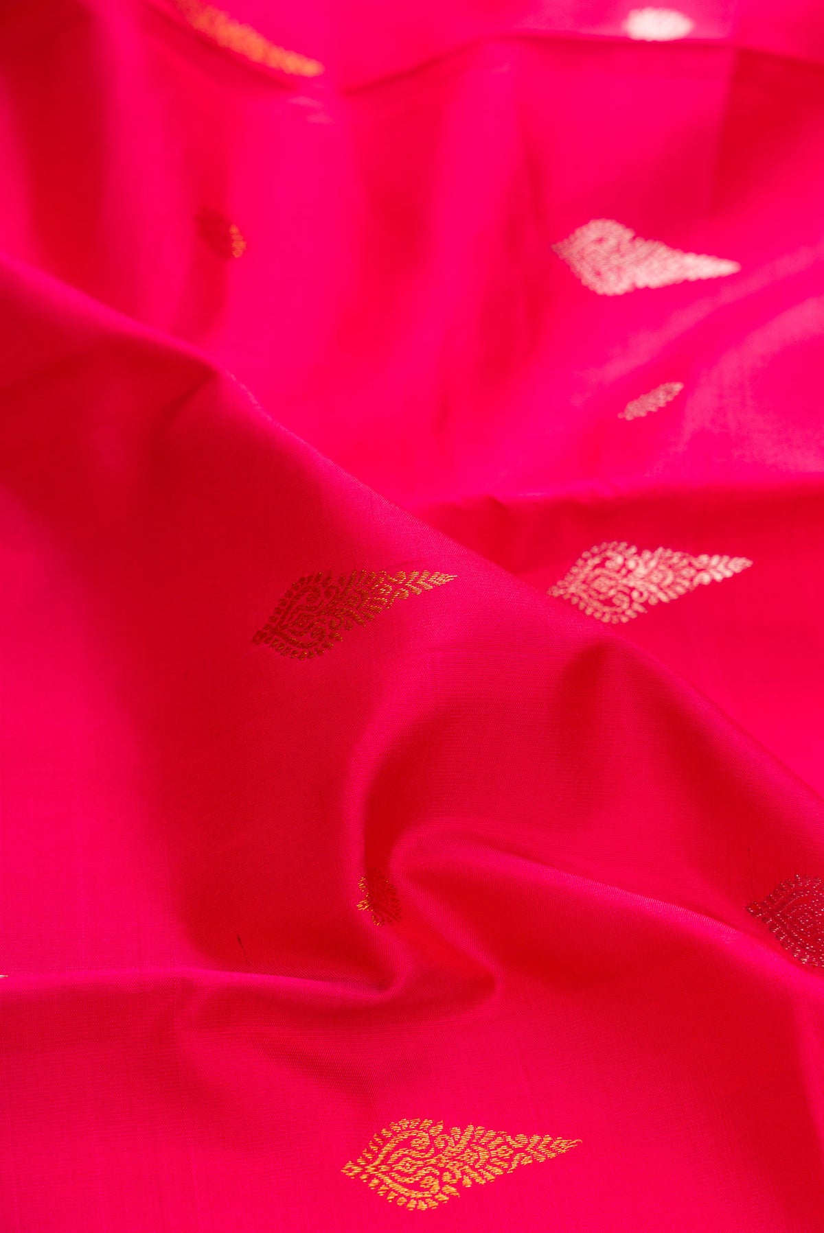 Close up of Dark Pink Dual Tone Kanchipuram Silk Saree with Zari Butta on the body and Fancy Border displaying folds