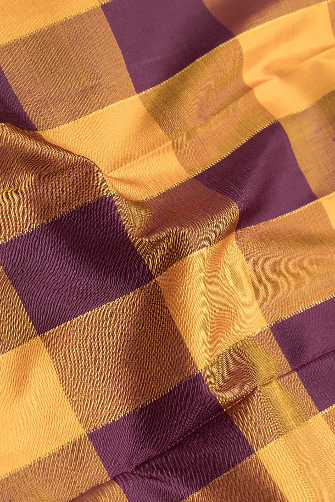 Close up of Mustard and Burgundy Color Kanjivaram Silk Saree with Checked design on the body and Zari Border.  displaying folds