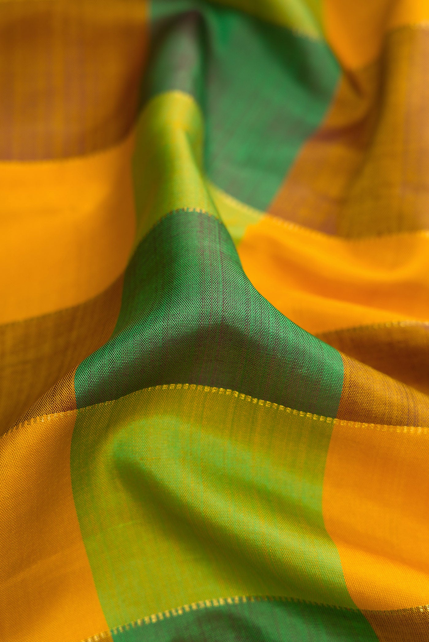 Close up of Mustard, Parrot Green and Bottle Green Color Kanjivaram Silk Saree with Checked design on the body and Temple Border.  displaying folds