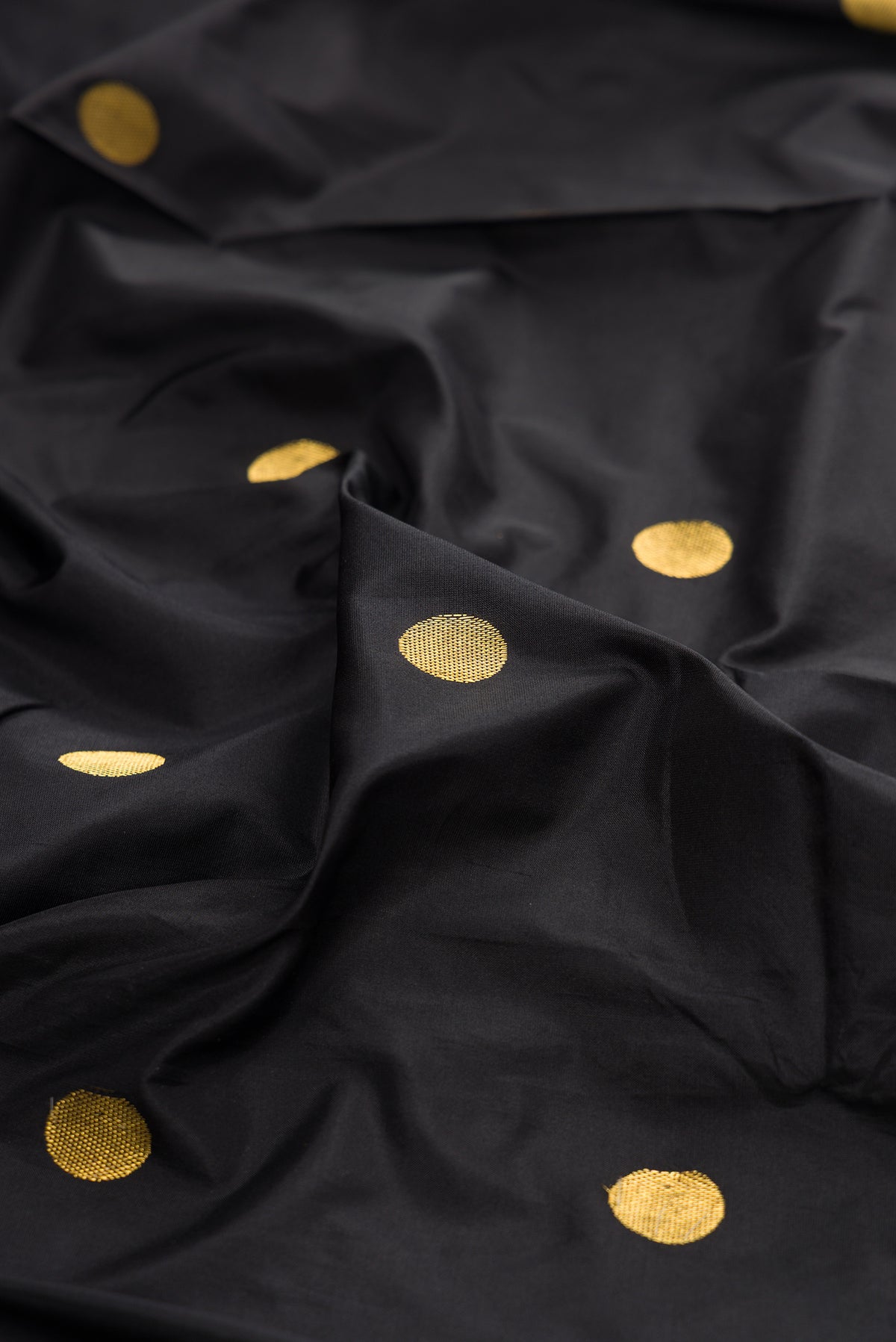 Close up of Pure Silk Black Bangalore Saree with Zari Butta on the body and Temple Border.  displaying folds