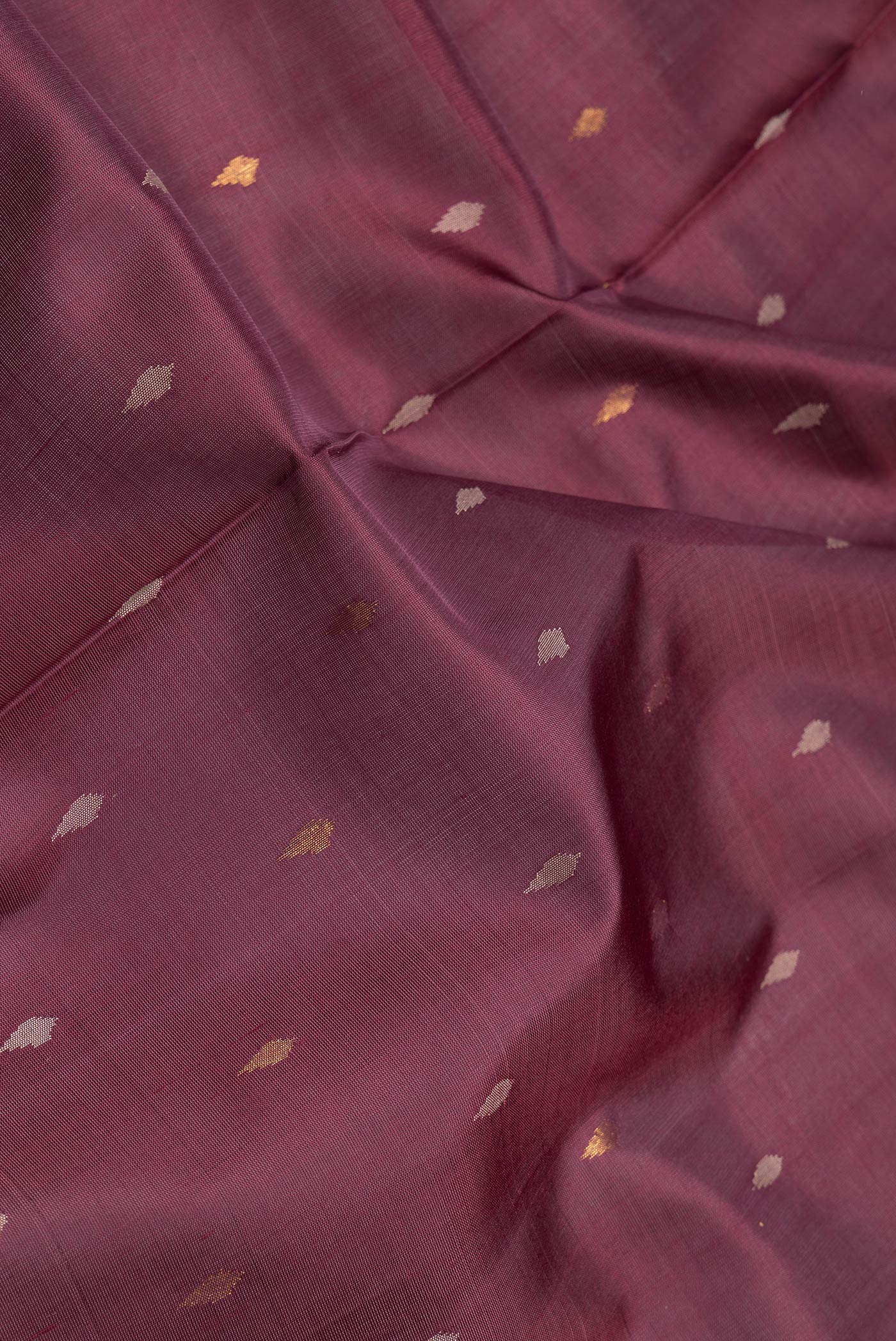 Close up of Maroon Dual Tone Uppada Silk Saree with Zari And Thread Butta on the body and Fancy Border.  displaying folds
