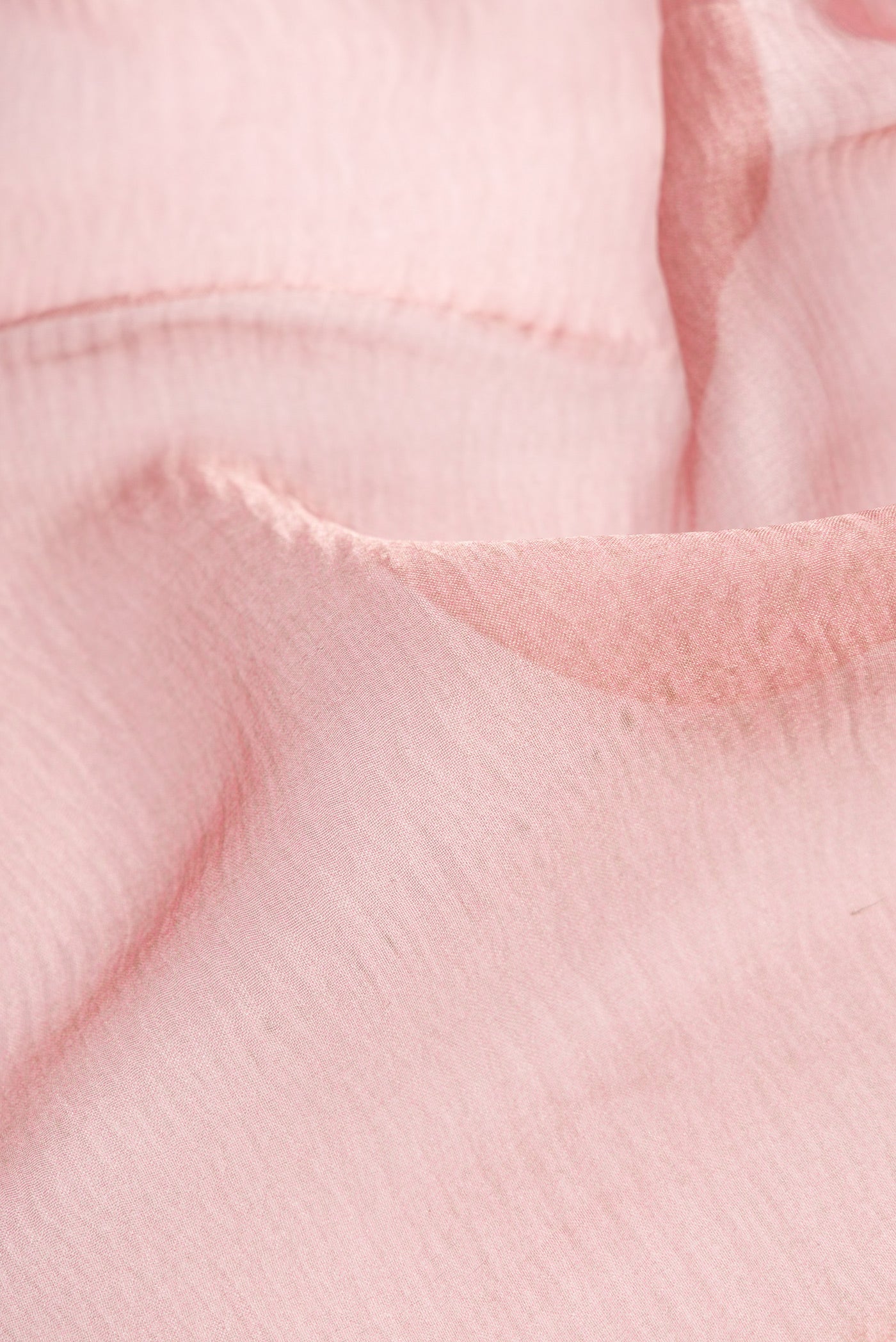 Close up of Rose Gold Dual Tone Organza Silk Saree with Plain Body and Embroidery Border.  displaying folds