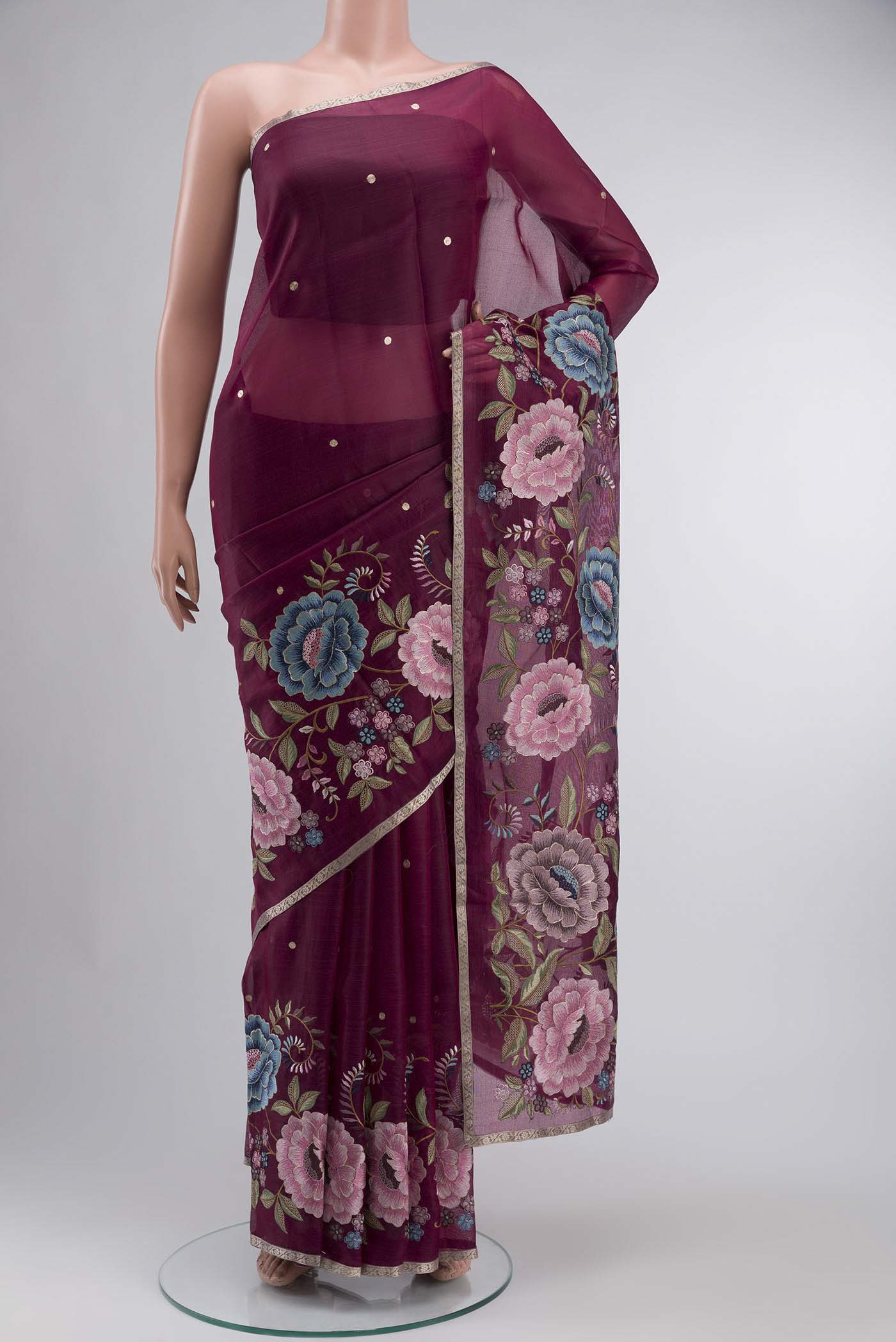 Maroon Organza Silk Saree with Embroidery on the body and Zari Border displayed on a mannequin