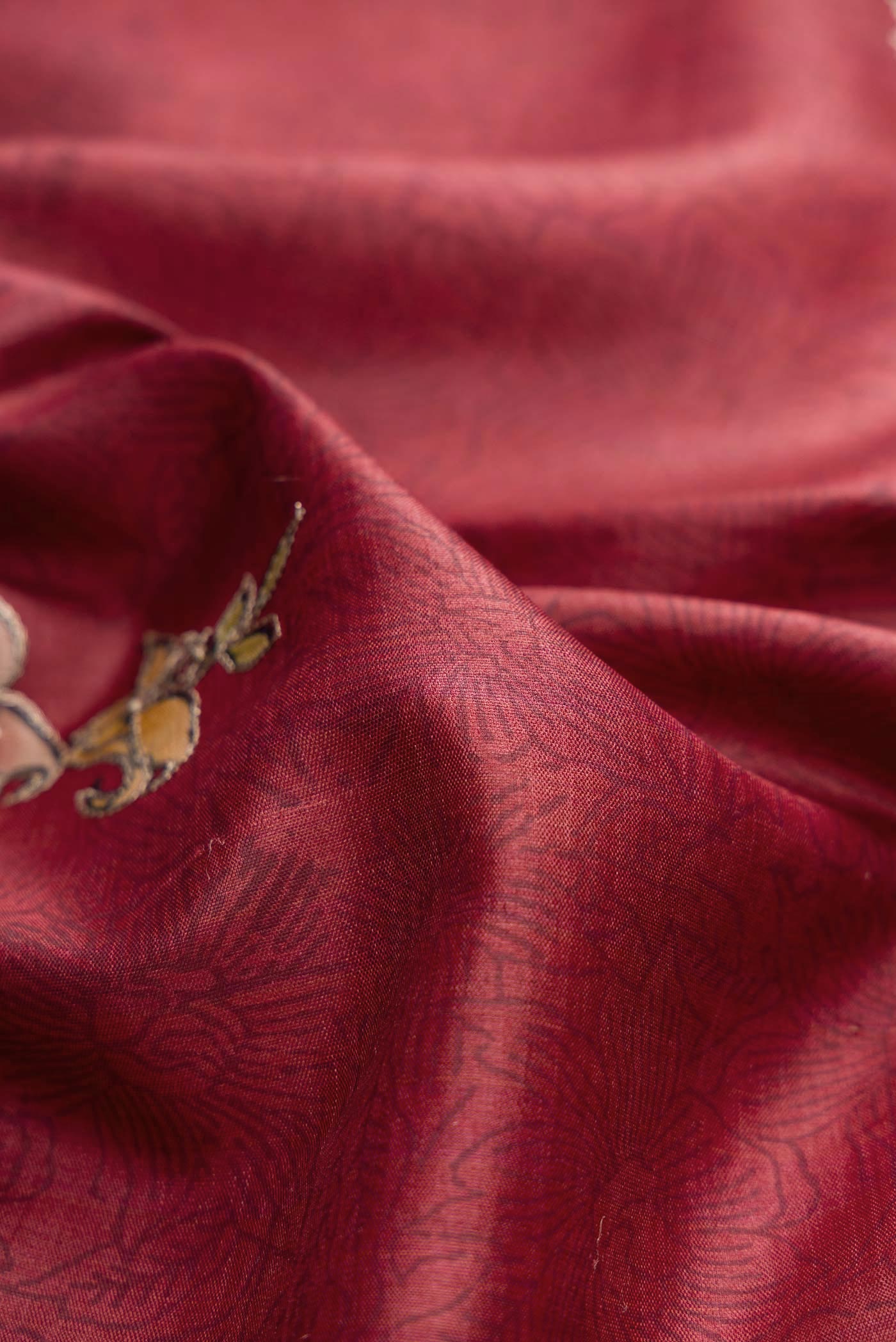 Close up of Maroon Tussar Silk Saree with Floral Print on the body and Embroidery Border displaying folds