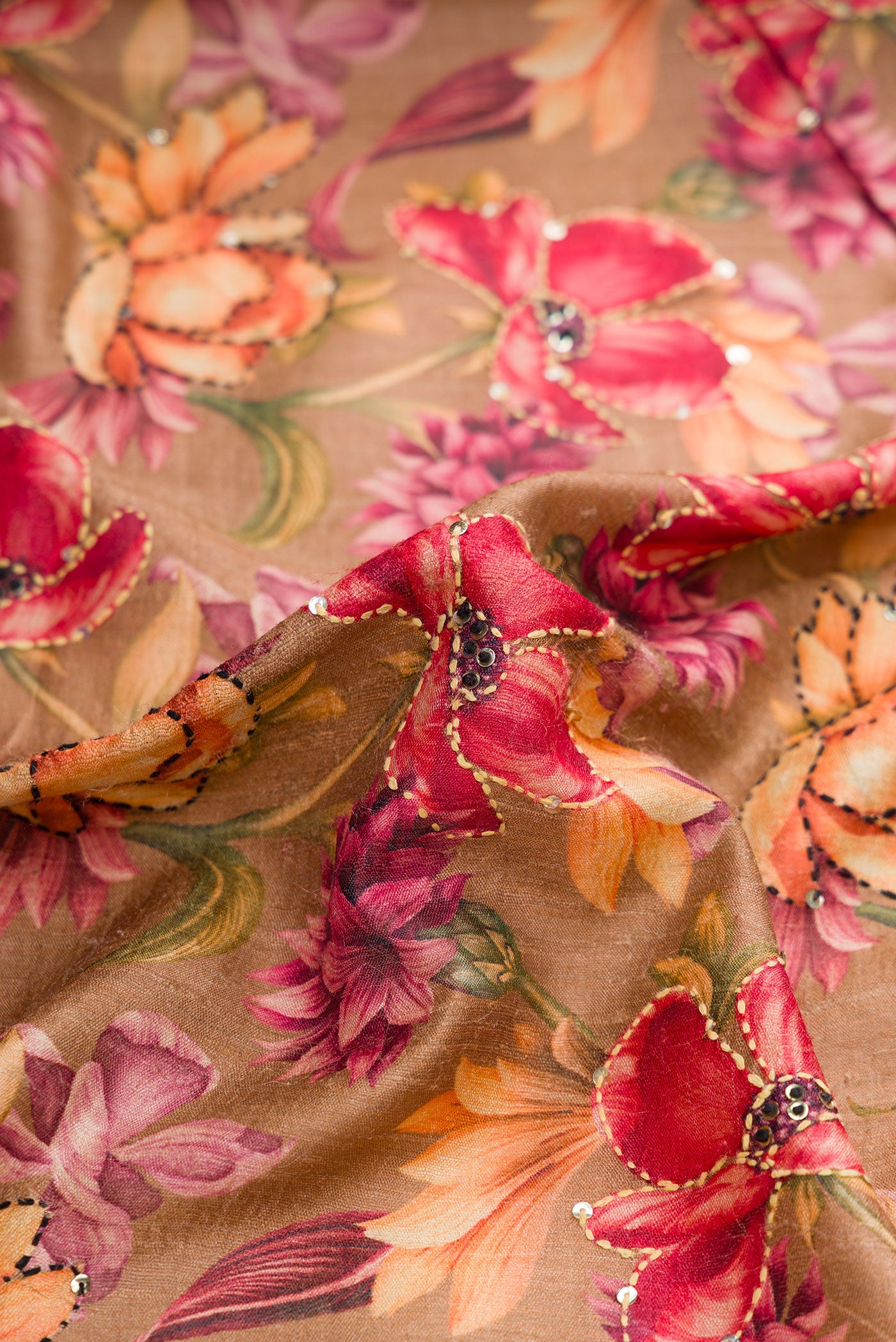 Close up of Brown Dual Tone Tussar Saree with Printed design on the body and Embroidery Border.  displaying folds