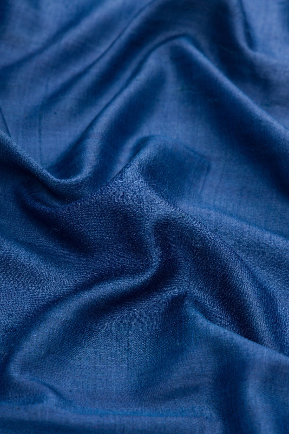 Close up of Navy Blue Dual Tone Tussar Silk Saree with Plain Body and Embroidery Border.  displaying folds