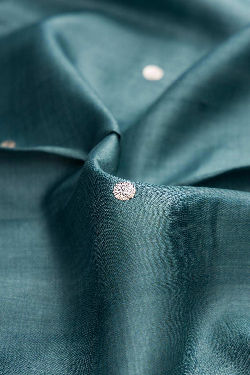 Close up of Blue Grey Dual Tone Tussar Silk Saree with Embroidery on the body and Embroidery Border displaying folds