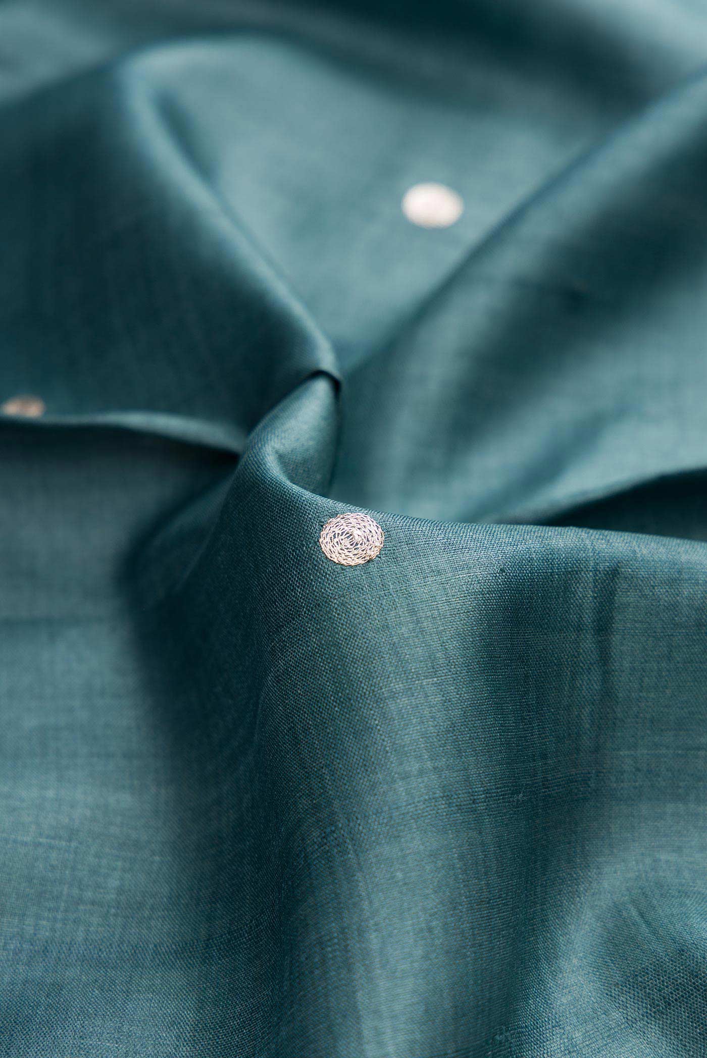 Close up of Blue Grey Dual Tone Tussar Silk Saree with Embroidery on the body and Embroidery Border displaying folds