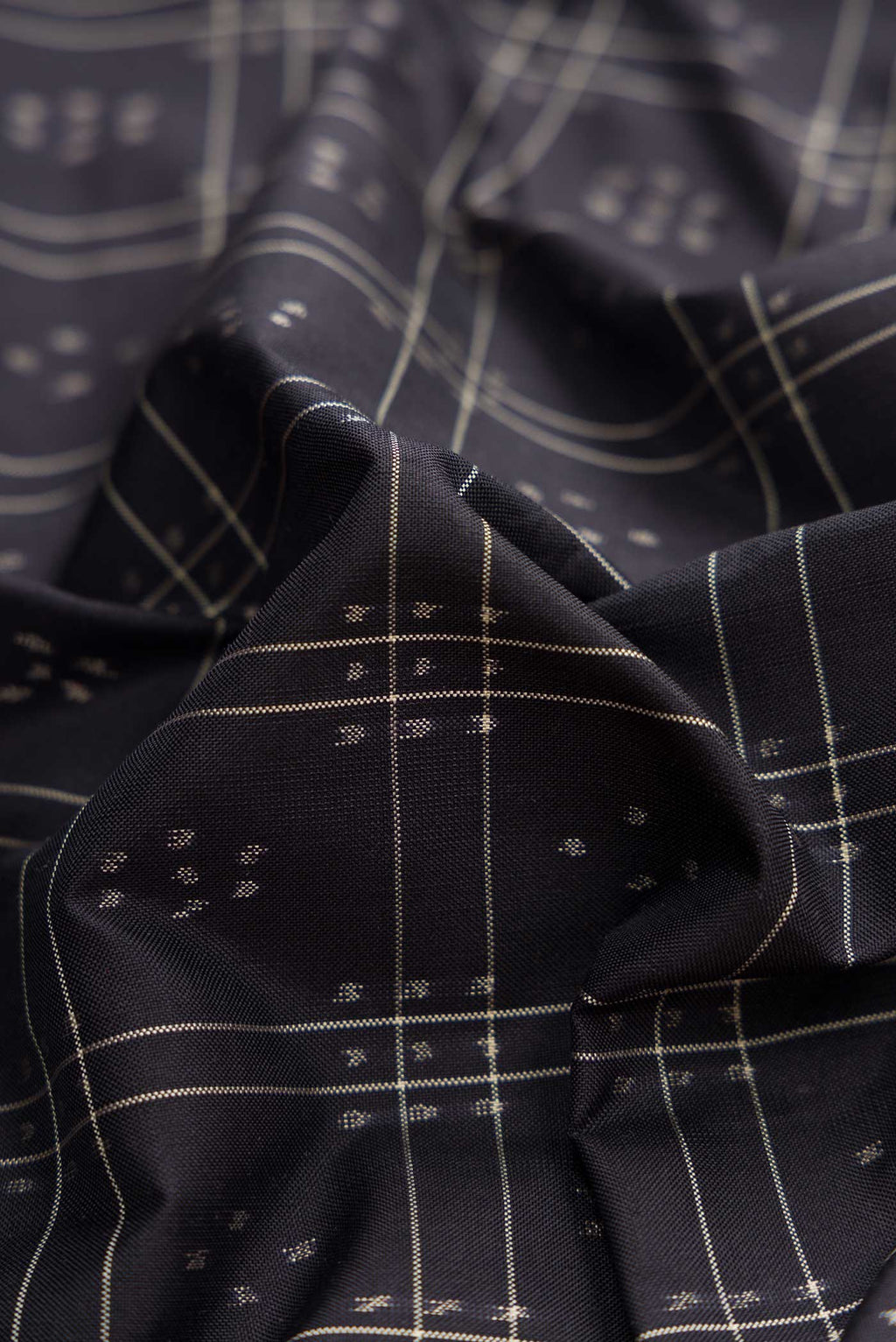 Close up of Black Dual Tone Double Ikat Saree with Ikat Print on the body and Plain Border displaying folds