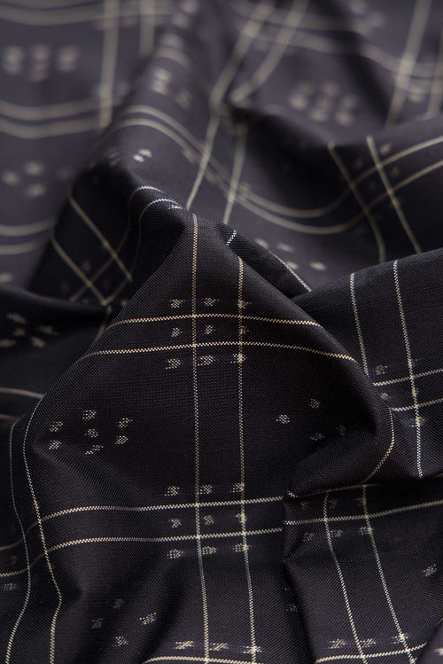 Close up of Black Dual Tone Double Ikat Saree with Ikat Print on the body and Plain Border displaying folds