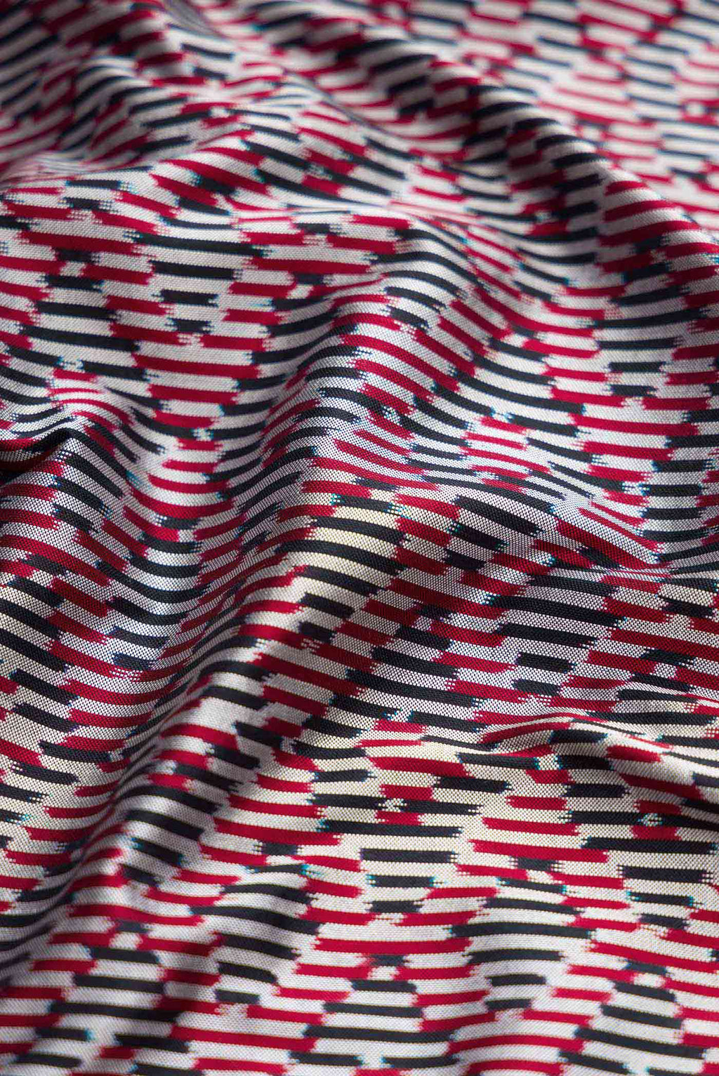 Close up of Burgundy Dual Tone Double Ikat Saree with Ikat Print on the body and Zari Border displaying folds
