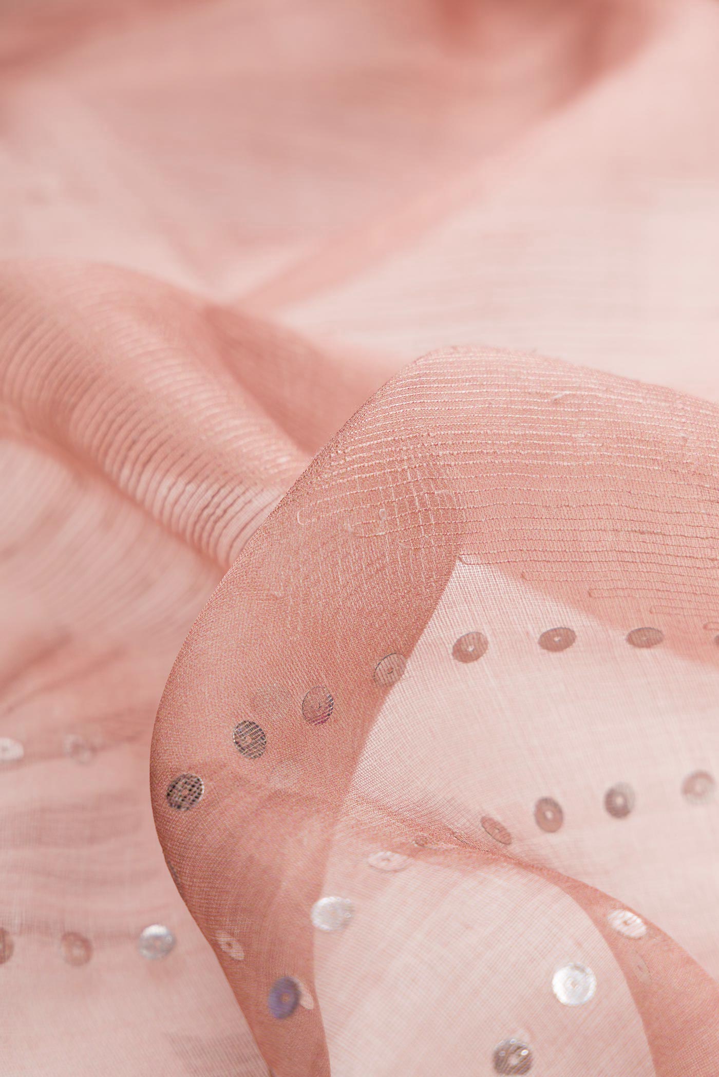 Close up of Peach Dual Tone Tussar Silk Saree with Embroidery on the body and Embroidery Border displaying folds