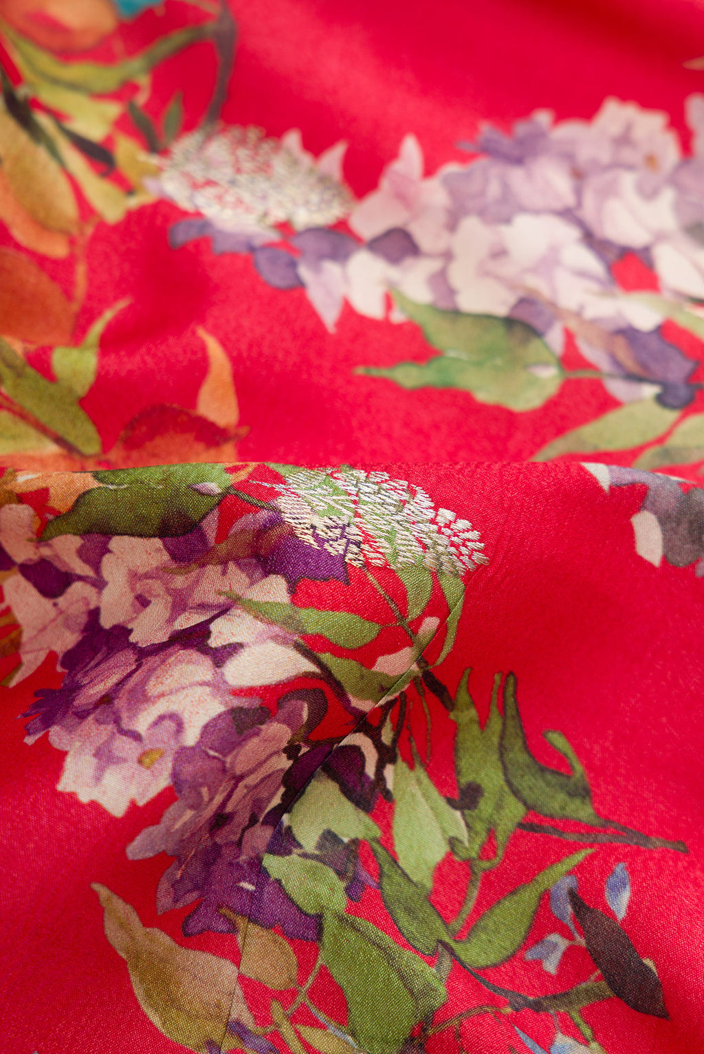 Close up of Red Dual Tone Tussar Saree with Printed design on the body and Zari Border.  displaying folds