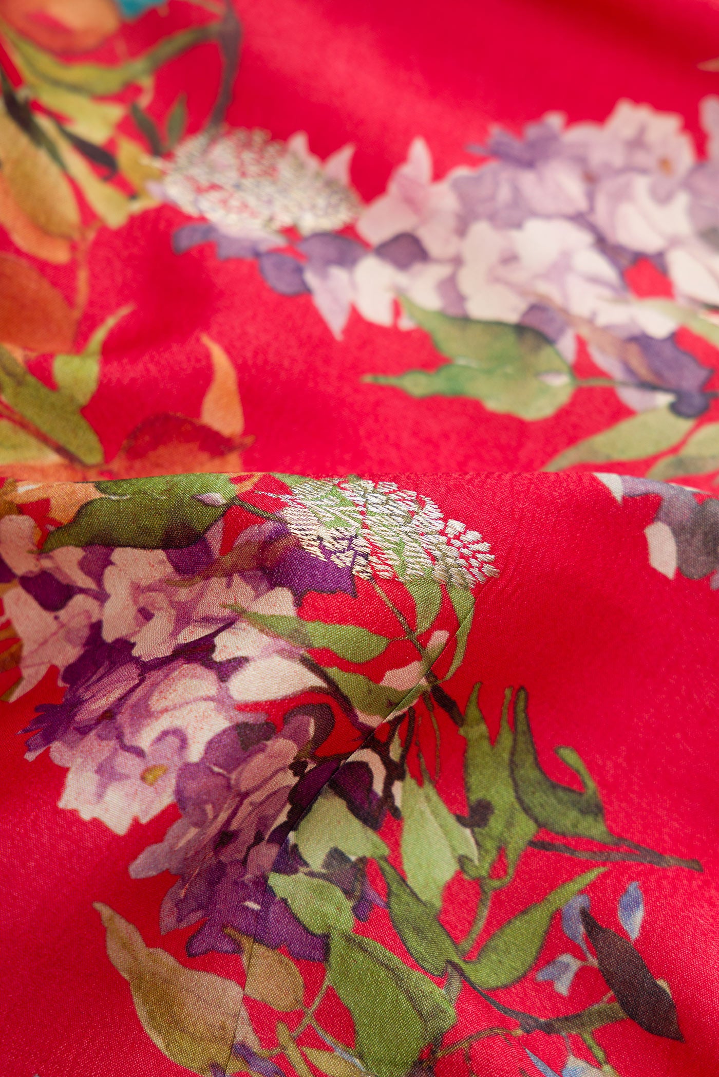 Close up of Red Dual Tone Tussar Saree with Printed design on the body and Zari Border.  displaying folds