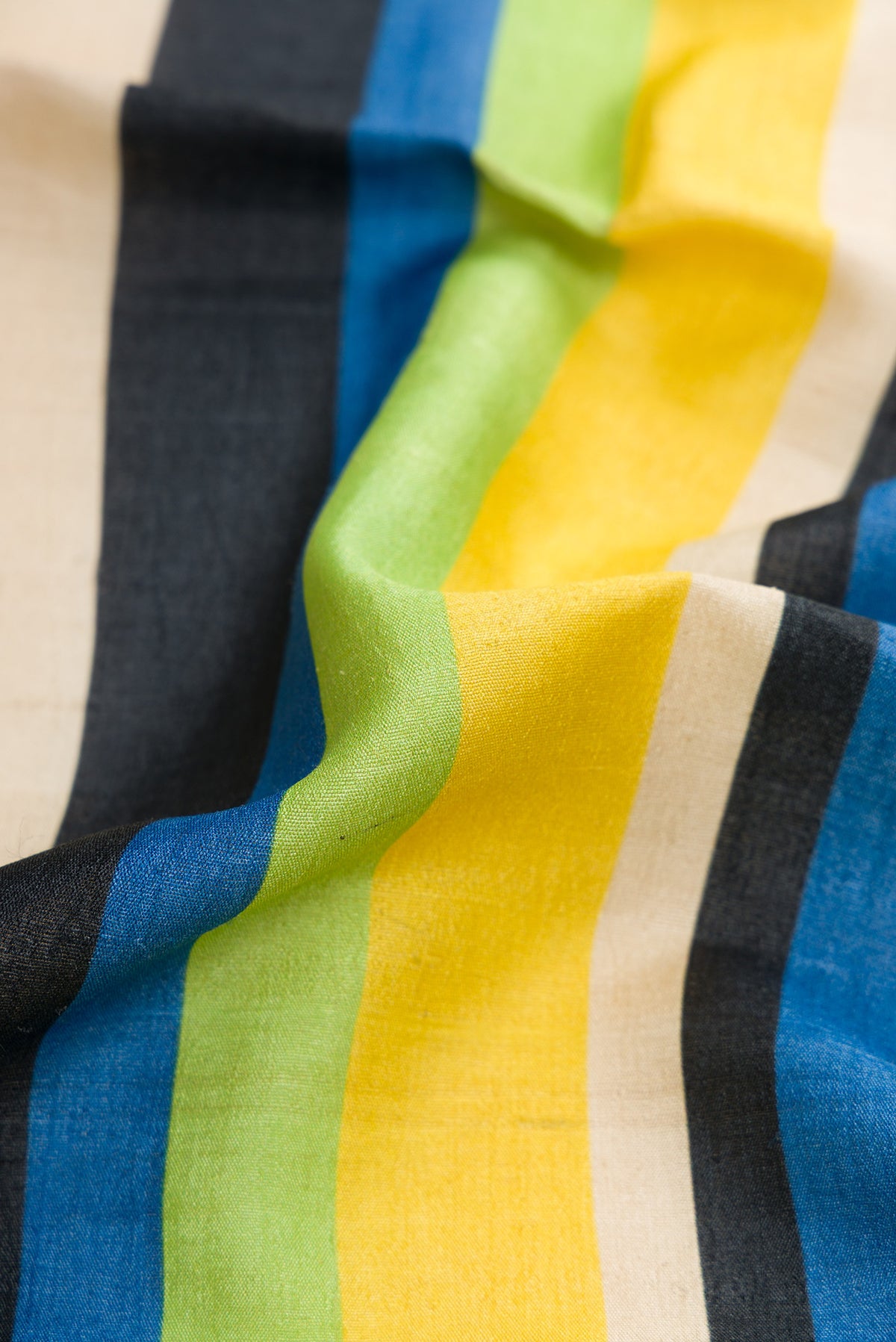Close up of Parrot Green,Blue and Black Color Tussar Silk Saree with Stripes on the body and Zari Border.  displaying folds