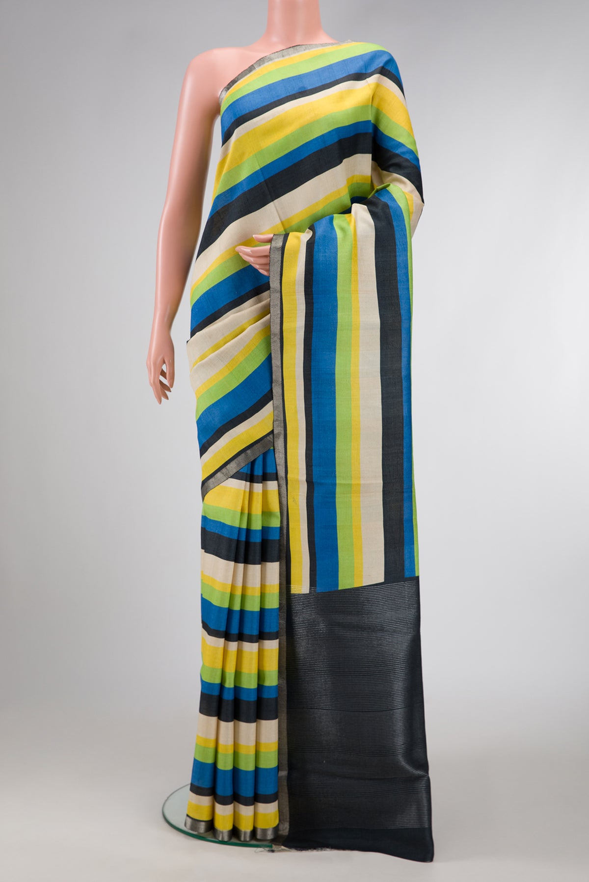 Parrot Green,Blue and Black Color Tussar Silk Saree with Stripes on the body and Zari Border.  displayed on a mannequin