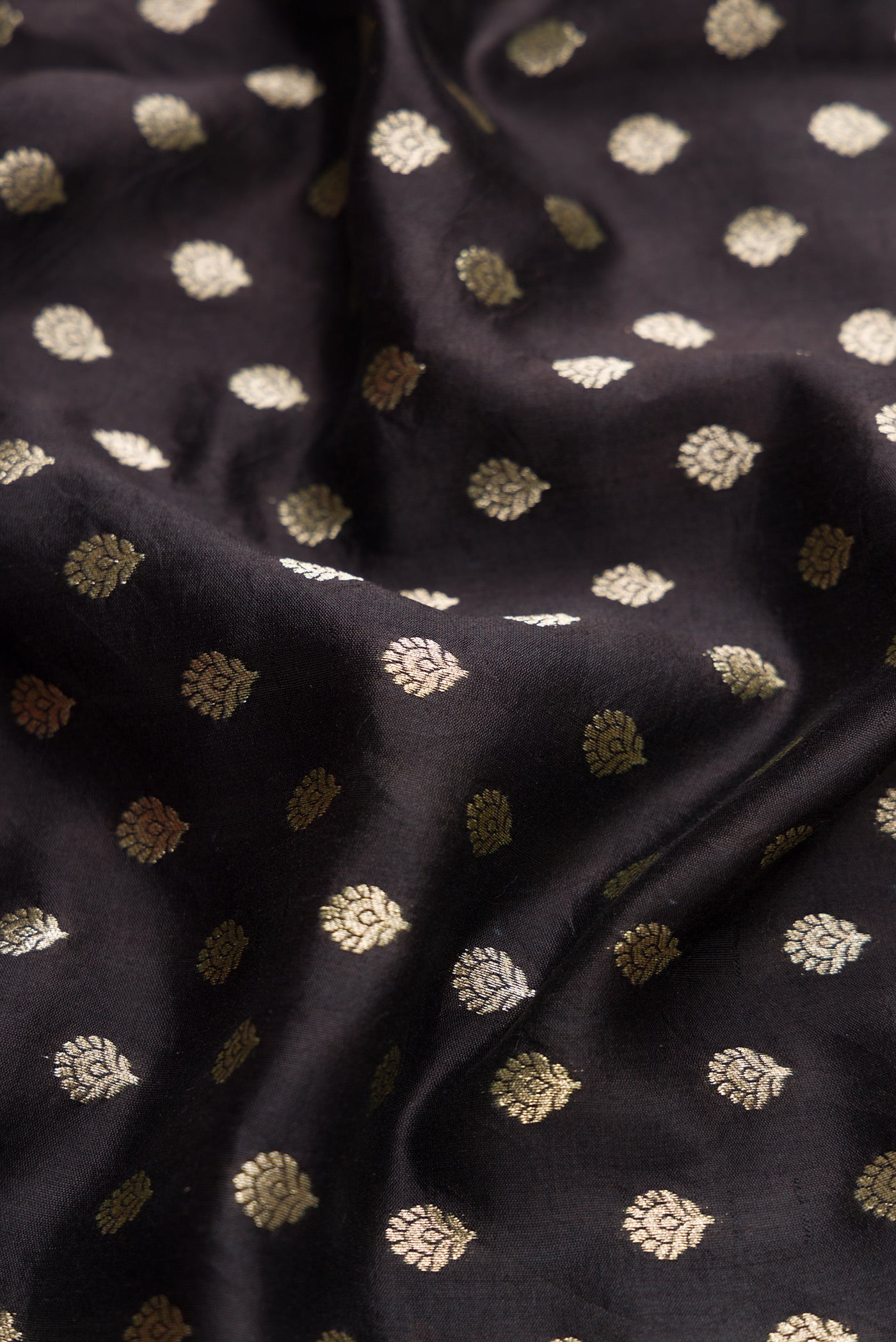 Close up of Black Dual Tone Tussar Silk Saree with Zari Butta on the body and Without Border.  displaying folds