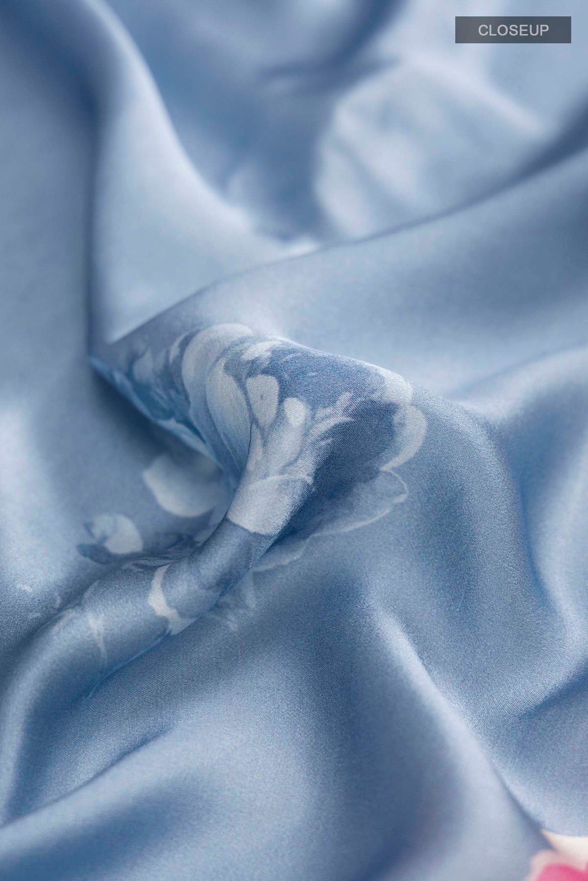 Close up of Blue Satin Crepe Saree Printed design on the body and Without Border displaying folds