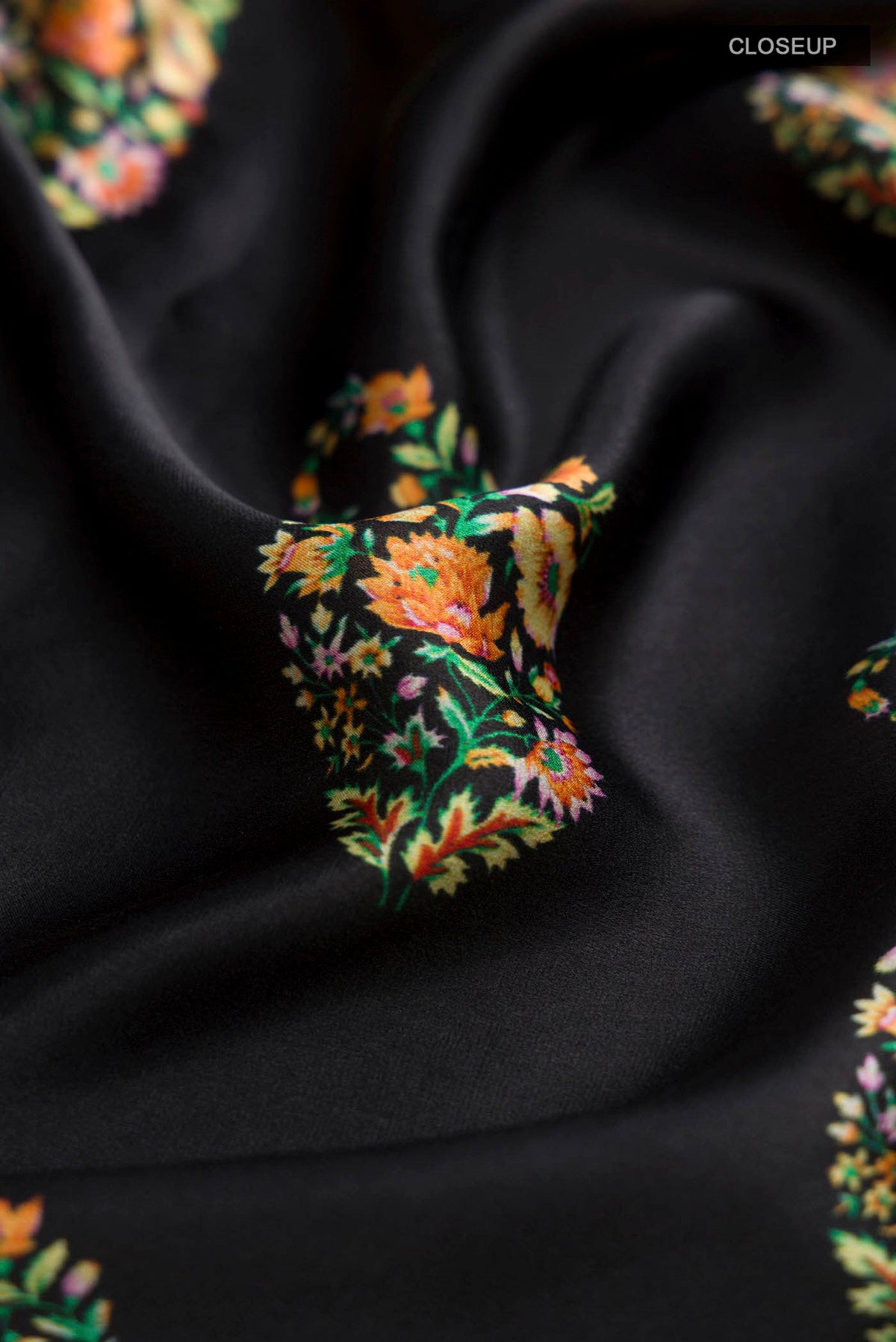 Close up of Black Satin Crepe Saree Printed design on the body and Plain Border displaying folds