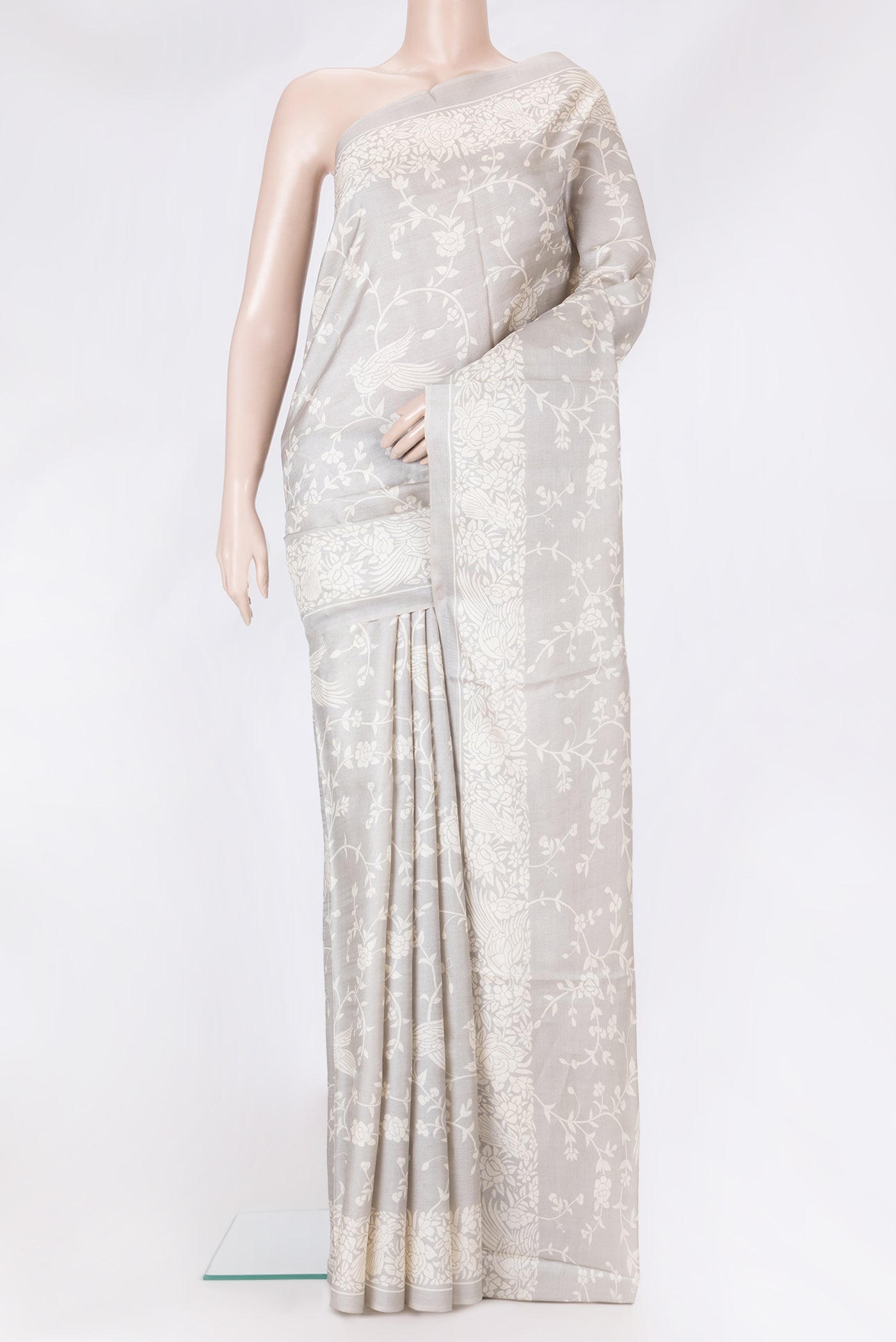 Grey Tussar Silk Saree with Printed design on the body and Printed Border.  displayed on a mannequin