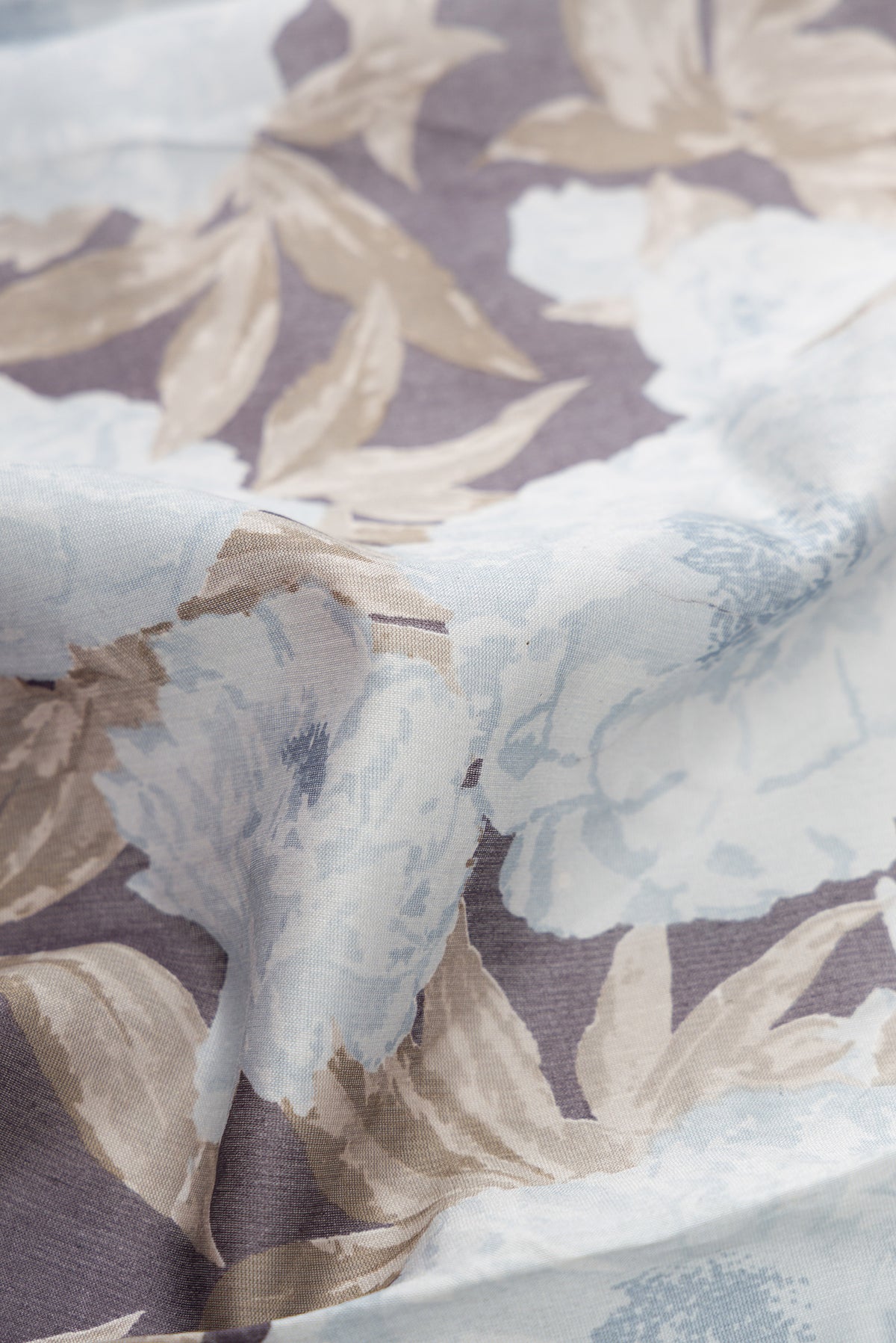 Close up of Grey Dual Tone Tussar Silk Saree with Printed design on the body and Plain Border.  displaying folds