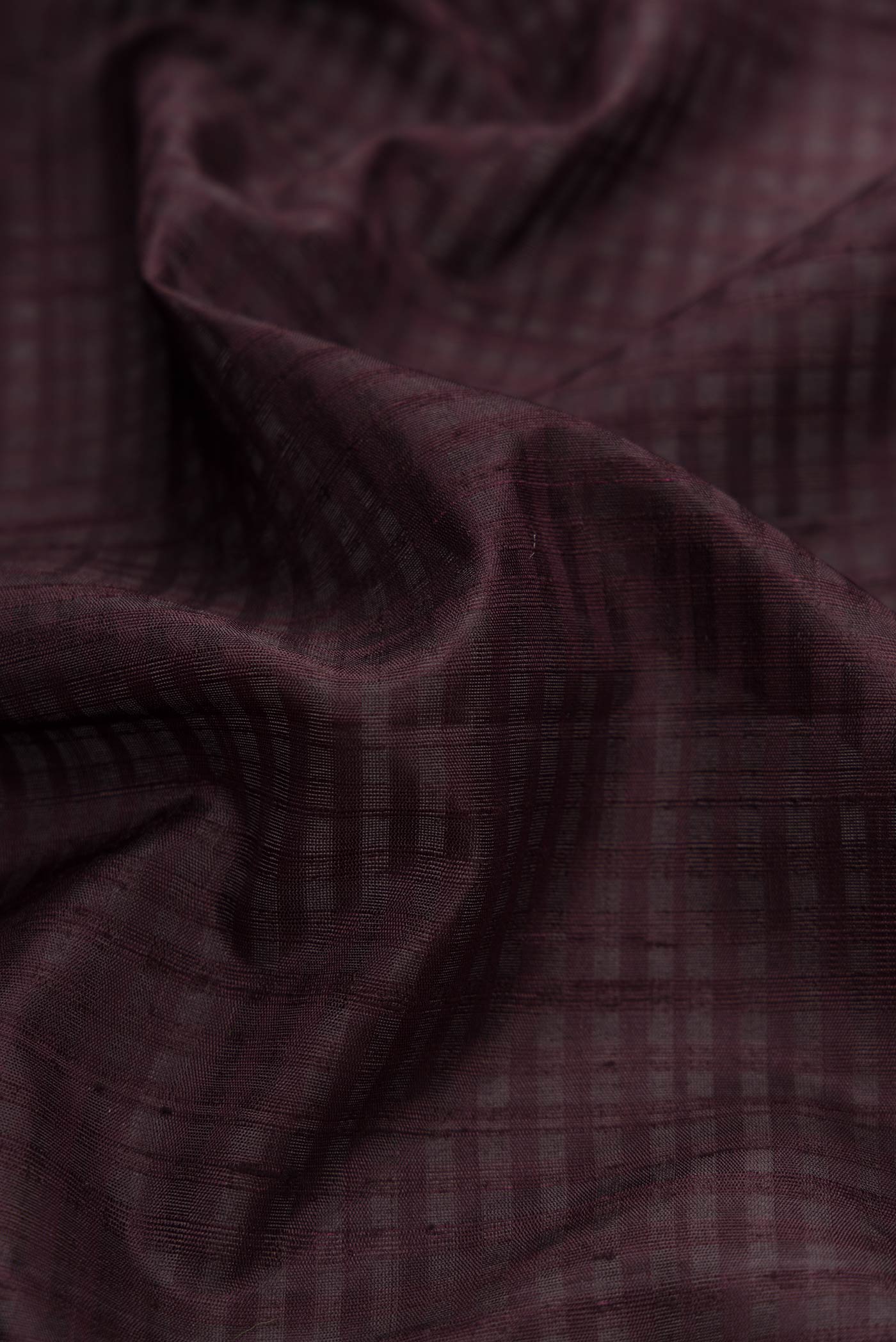 Close up of Coffee Brown Dual Tone Soft Silk Saree with Checked design on the body and Without Border.  displaying folds