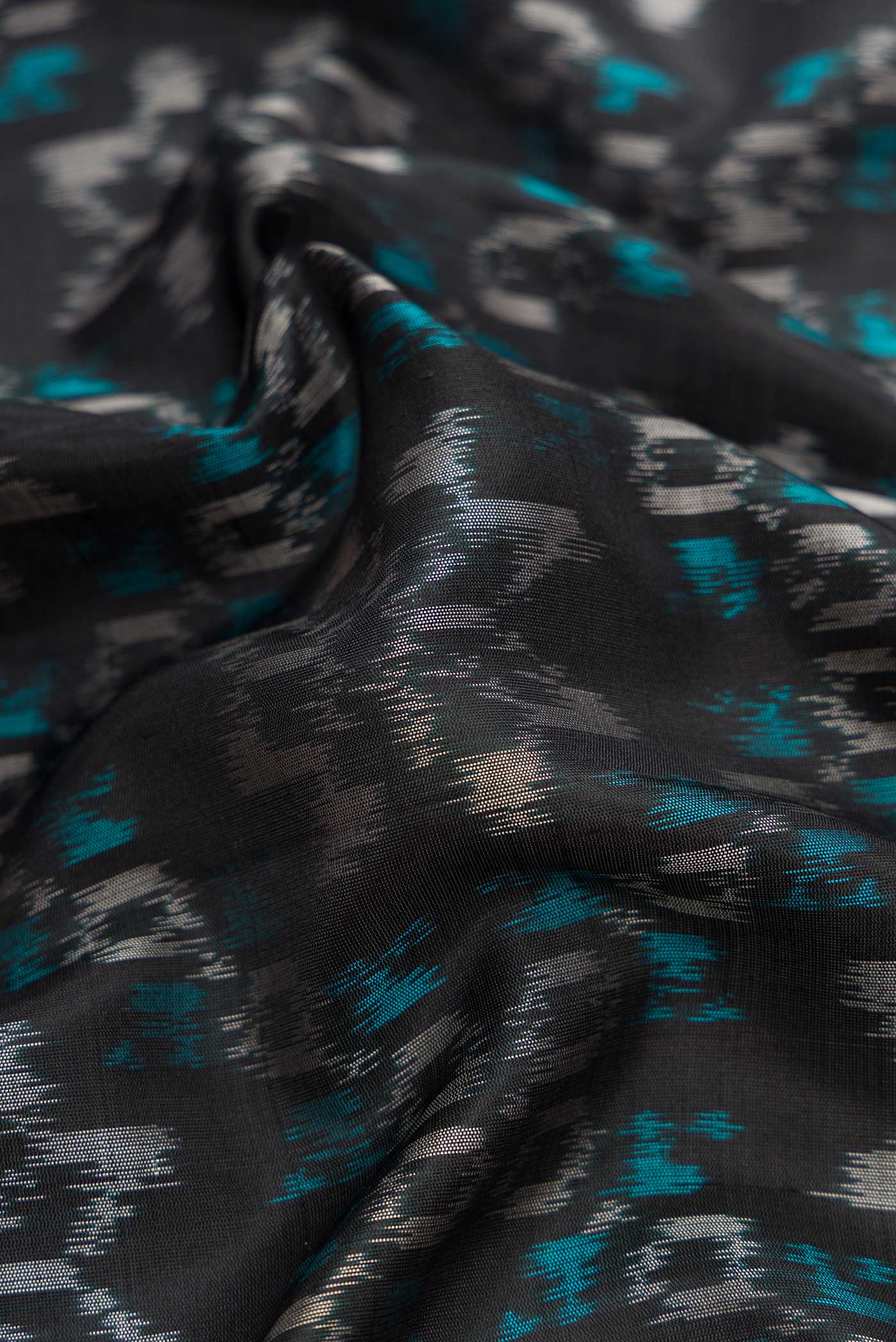 Close up of Black Dual Tone Soft Silk Saree with Ikat Print on the body and Zari Border.  displaying folds