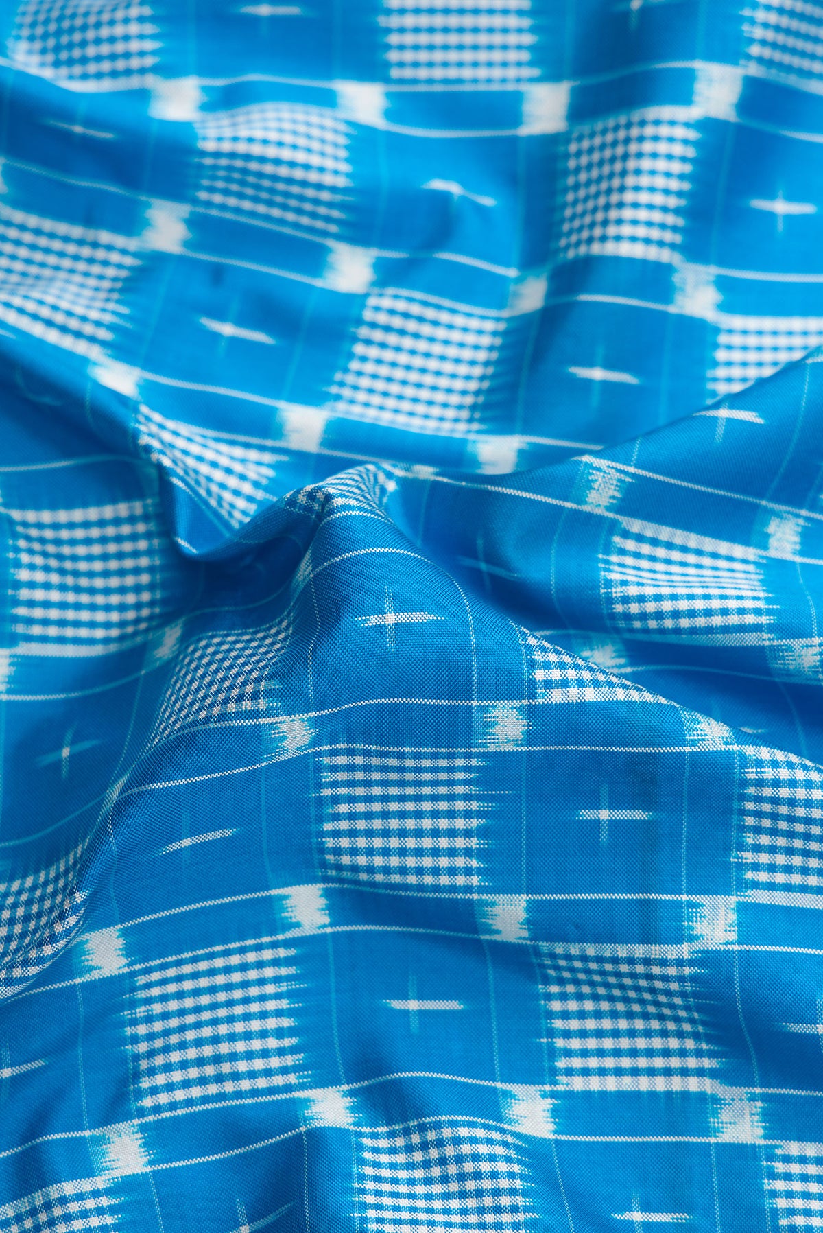 Close up of Sky Blue Dual Tone Double Ikat Saree with Ikat Print on the body and Zari Border.  displaying folds