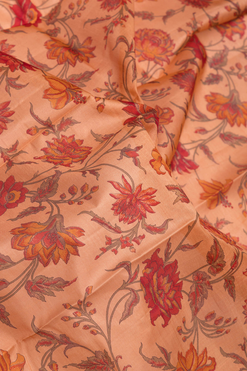 Close up of Peach Printed Silk Saree with Printed design on the body and Zari Border.  displaying folds
