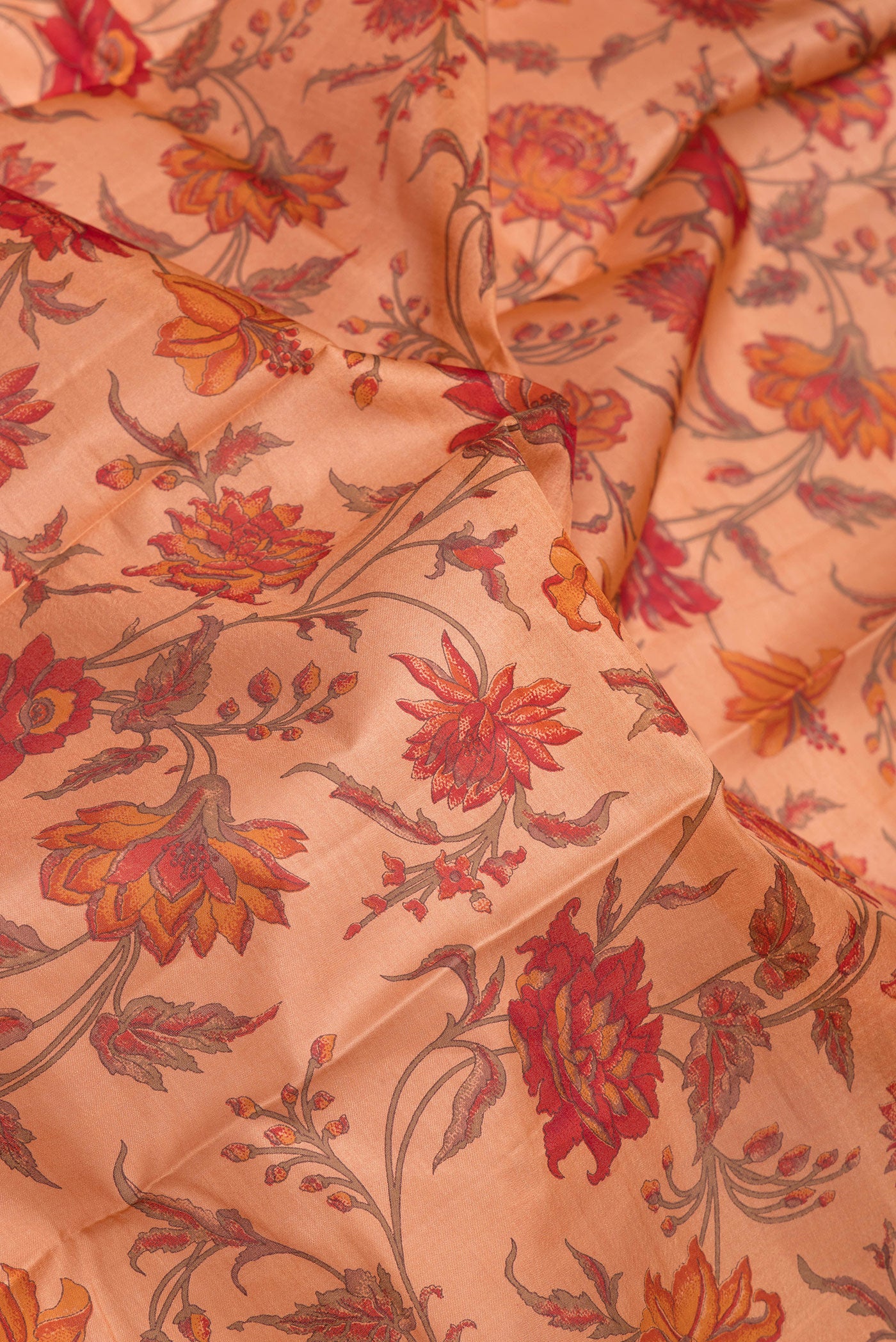Close up of Peach Printed Silk Saree with Printed design on the body and Zari Border.  displaying folds