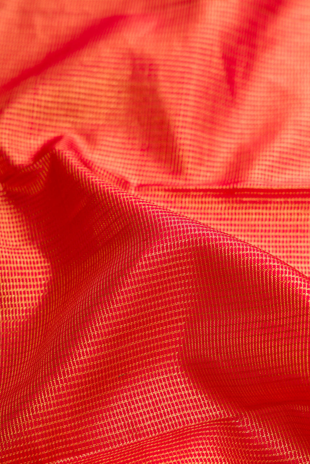 Close up of Red Dual Tone Kanchipuram Silk Saree with Zari Brocade on the body and Zari Border.  displaying folds