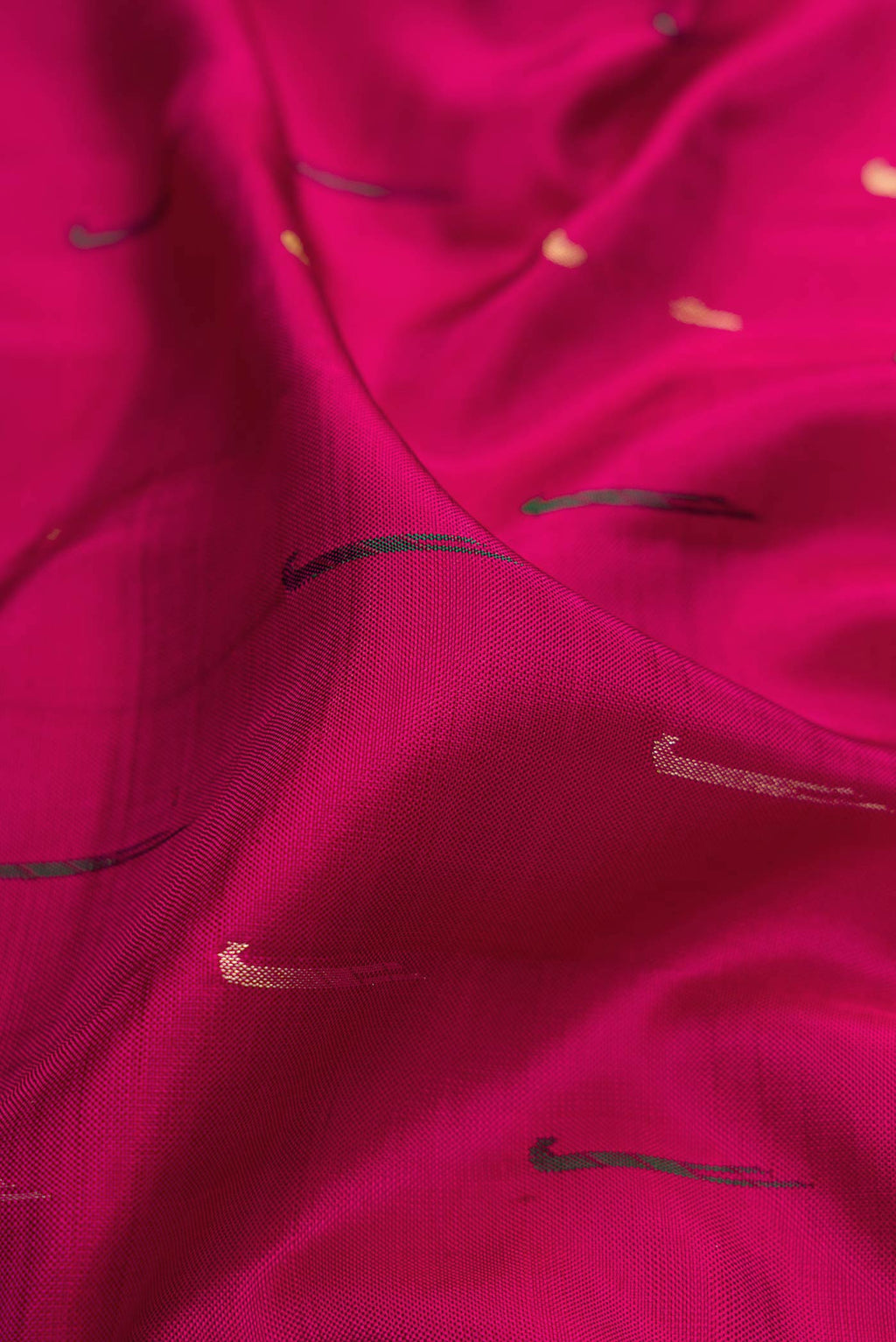 Close up of Magenta Dual Tone Kanchipuram Silk Saree with Zari And Thread Butta on the body and Zari Border.  displaying folds