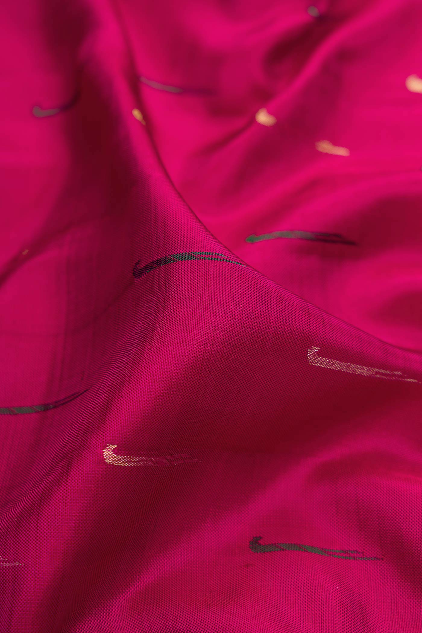 Close up of Magenta Dual Tone Kanchipuram Silk Saree with Zari And Thread Butta on the body and Zari Border.  displaying folds