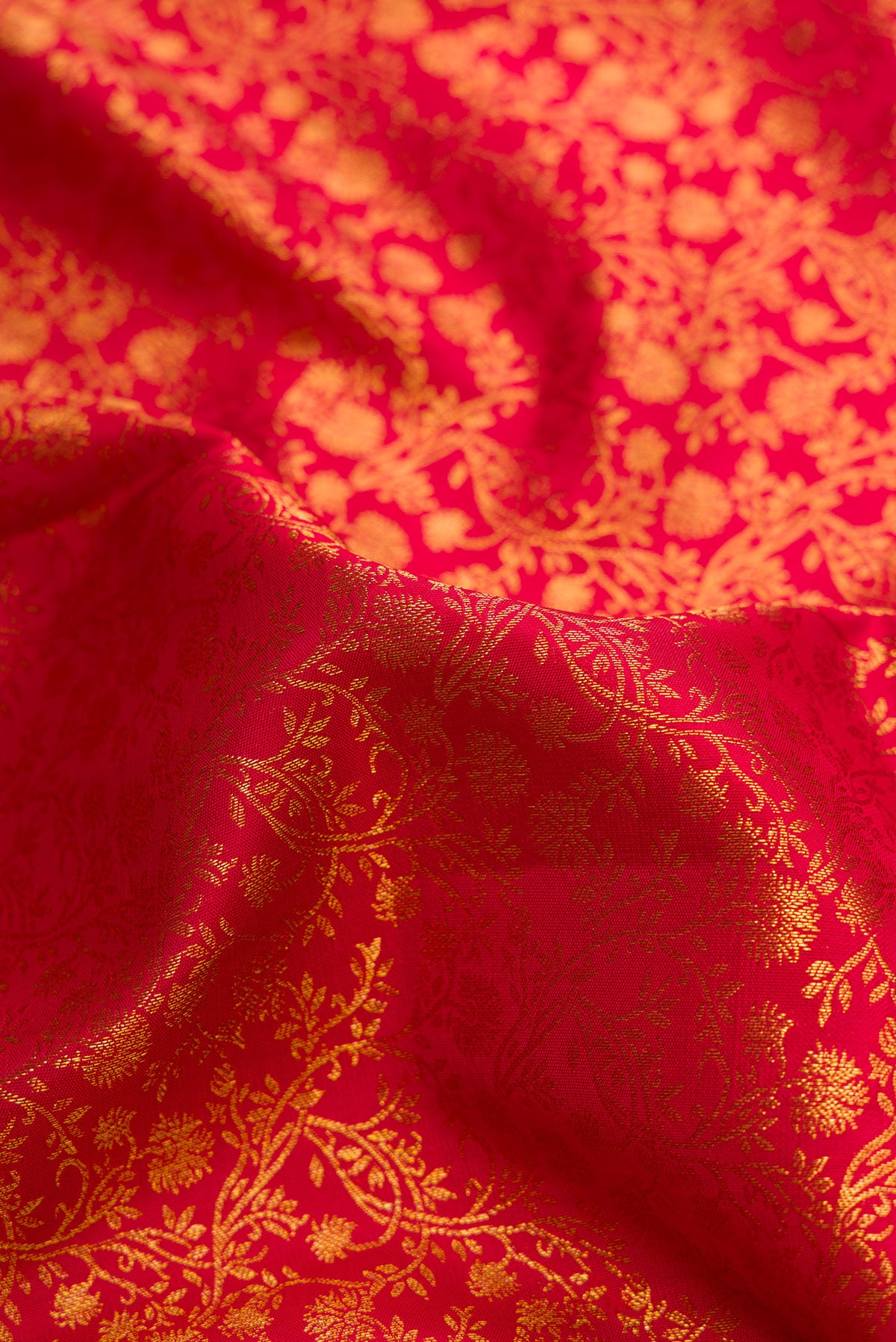 Close up of Red Dual Tone Kanjivaram Silk Saree with Zari Brocade on the body and Zari Border.  displaying folds
