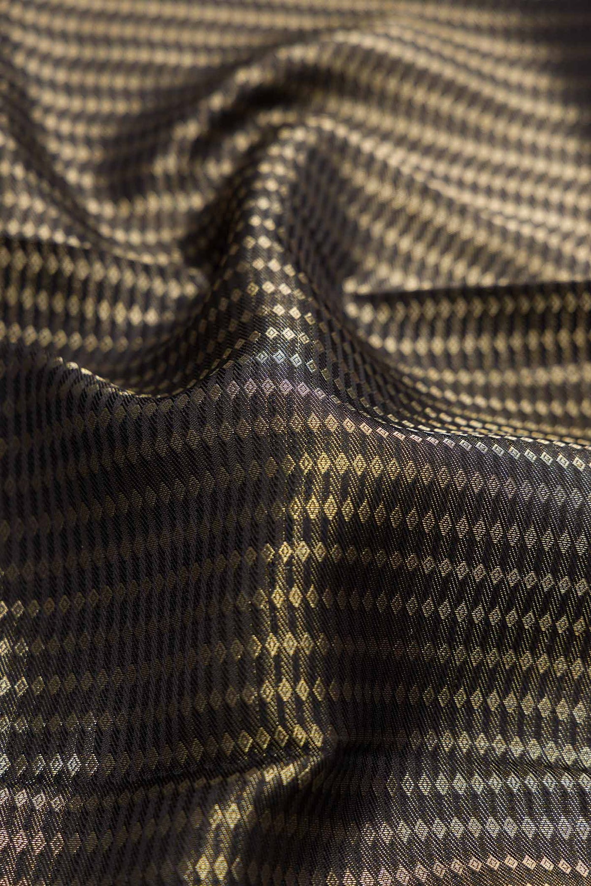 Close up of Black Dual Tone Kanjivaram Silk Saree with Zari Brocade on the body and Zari Border.  displaying folds
