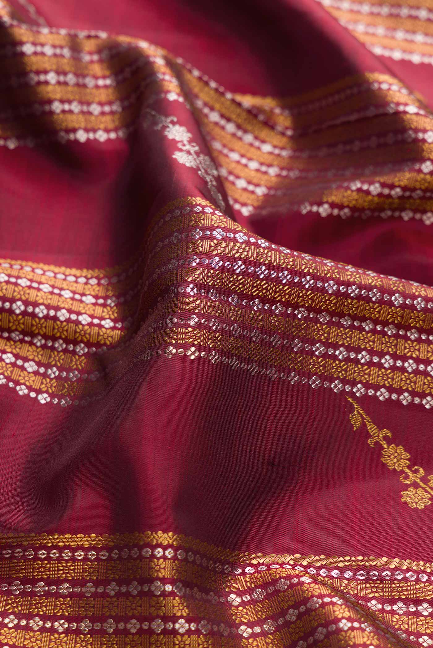Close up of Maroon Dual Tone Kanchipuram Silk Saree with Zari Brocade on the body and Zari Border displaying folds