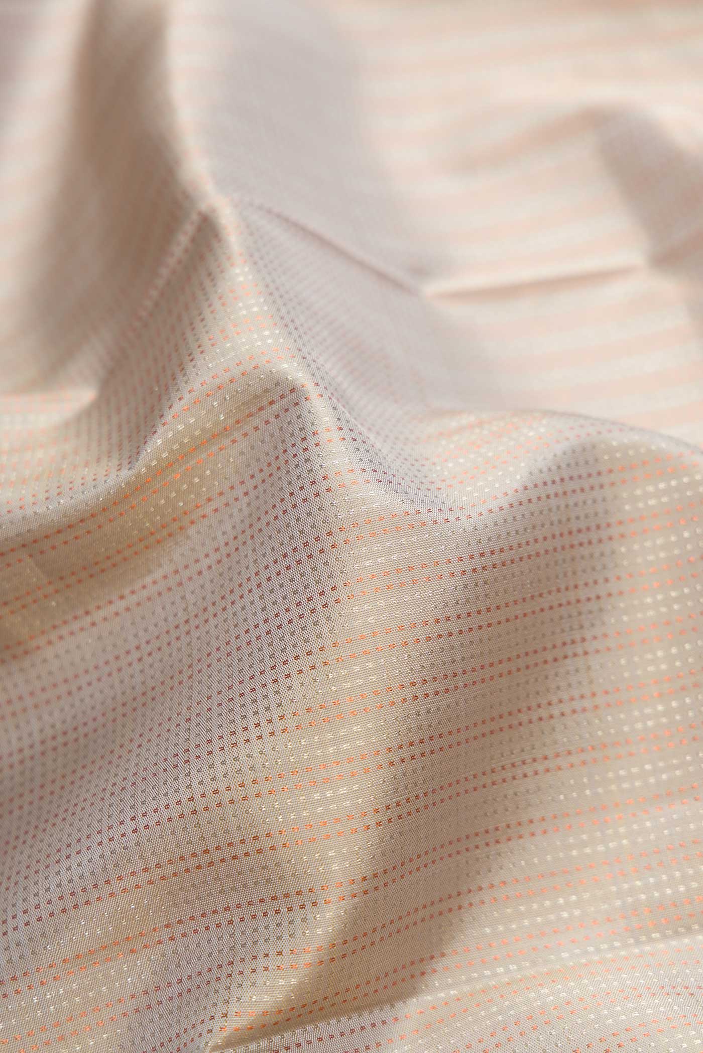 Close up of Beige Dual Tone Kanchipuram Silk Saree with Stripes on the body and Zari Border.  displaying folds