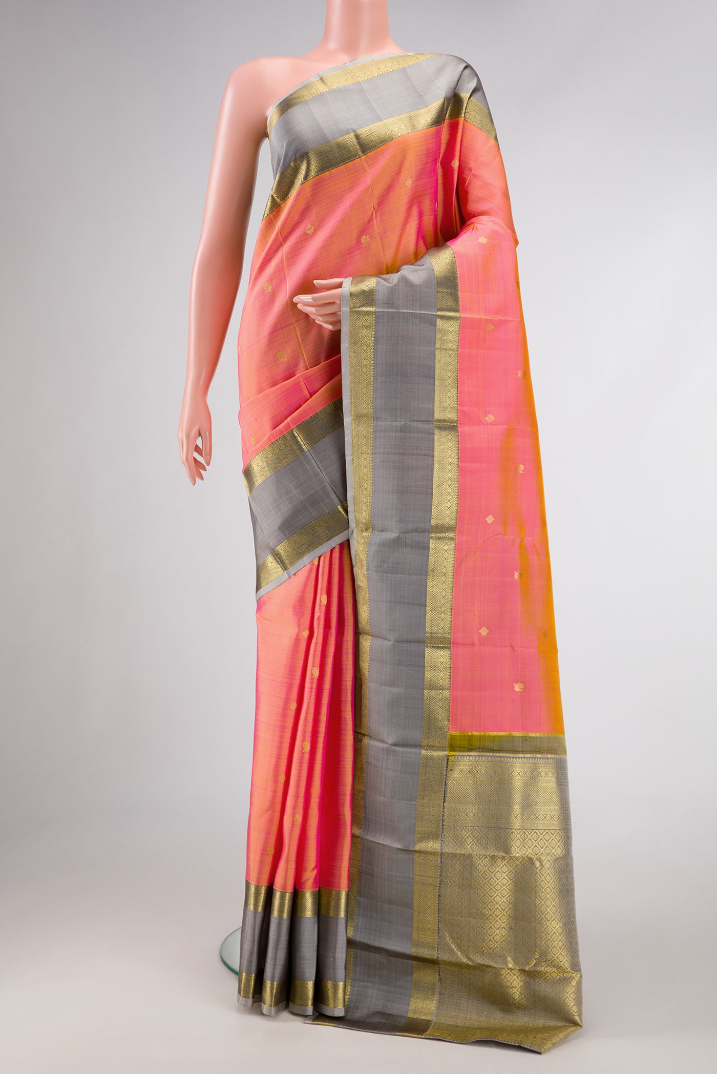 Orange Dual Tone Kanjivaram Silk Saree with Zari Butta on the body and Zari Border.  displayed on a mannequin