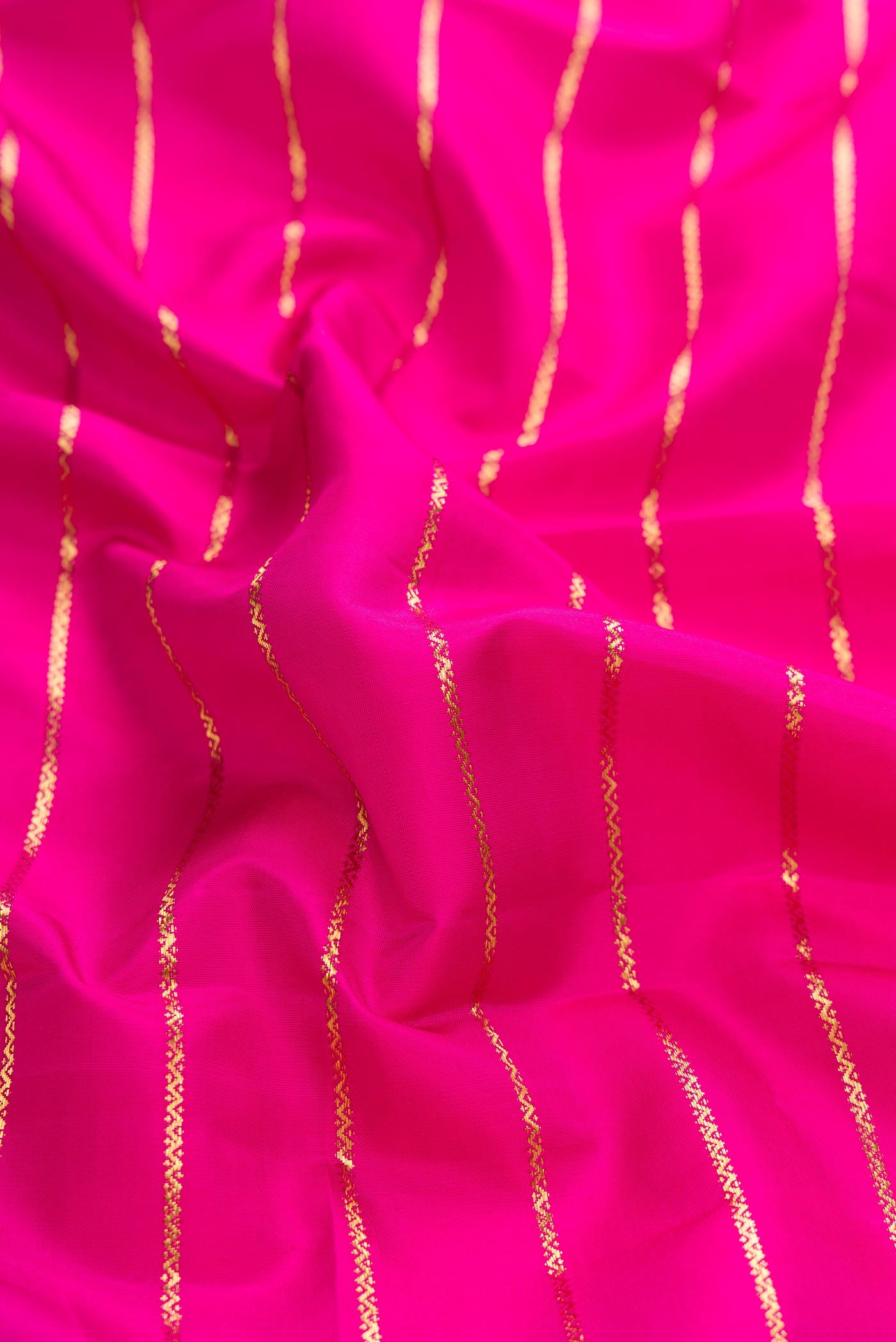 Close up of Pink Dual Tone Kanchipuram Silk Saree with Veldhari on the body and Zari Border displaying folds