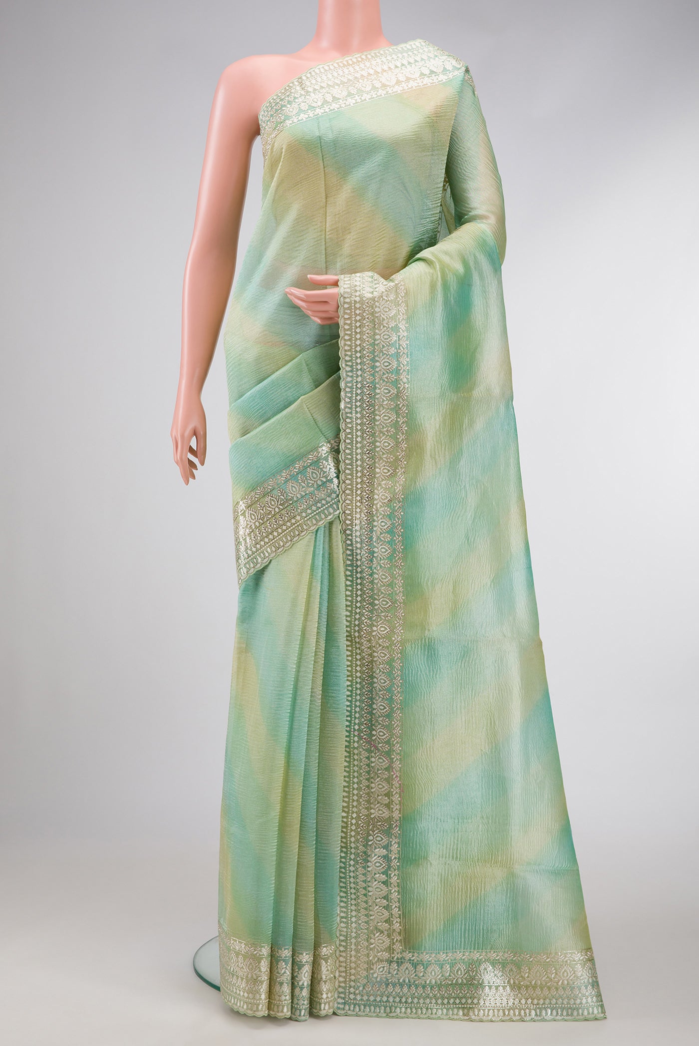 Pista Green Dual Tone Organza Silk Saree with Stripes on the body and Embroidery Border.  displayed on a mannequin