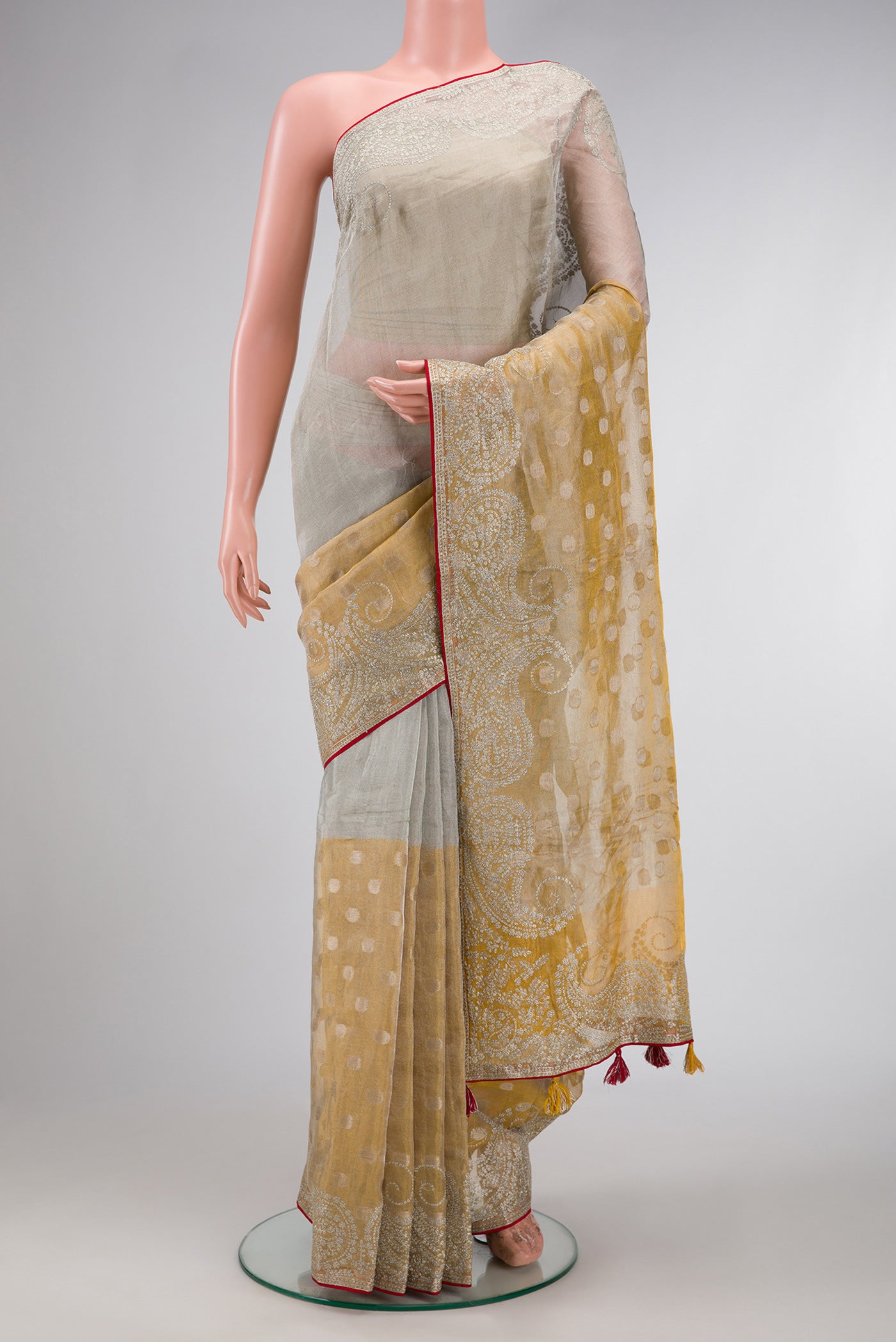 Gold Dual Tone Organza Silk Saree with Zari Butta on the body and Embroidery Border.  displayed on a mannequin